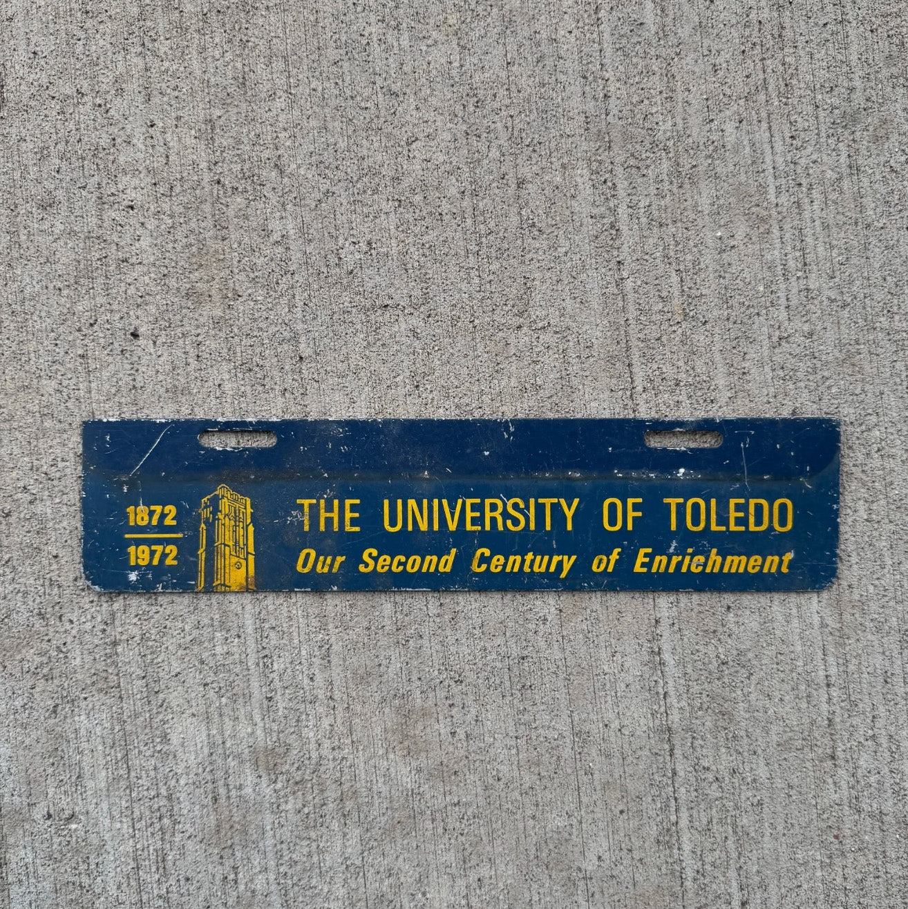 Photo of a 1972 University of Toledo Ohio License Plate Topper Auto Tag Garage Decor Vintage College Rockets Centennial with original patina
