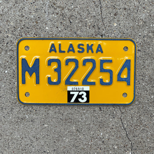 Photo of a 1973 Alaska Motorcycle License Plate Auto Tag Garage Decor Vintage Natural 1973 Sticker M 32254 with original patina