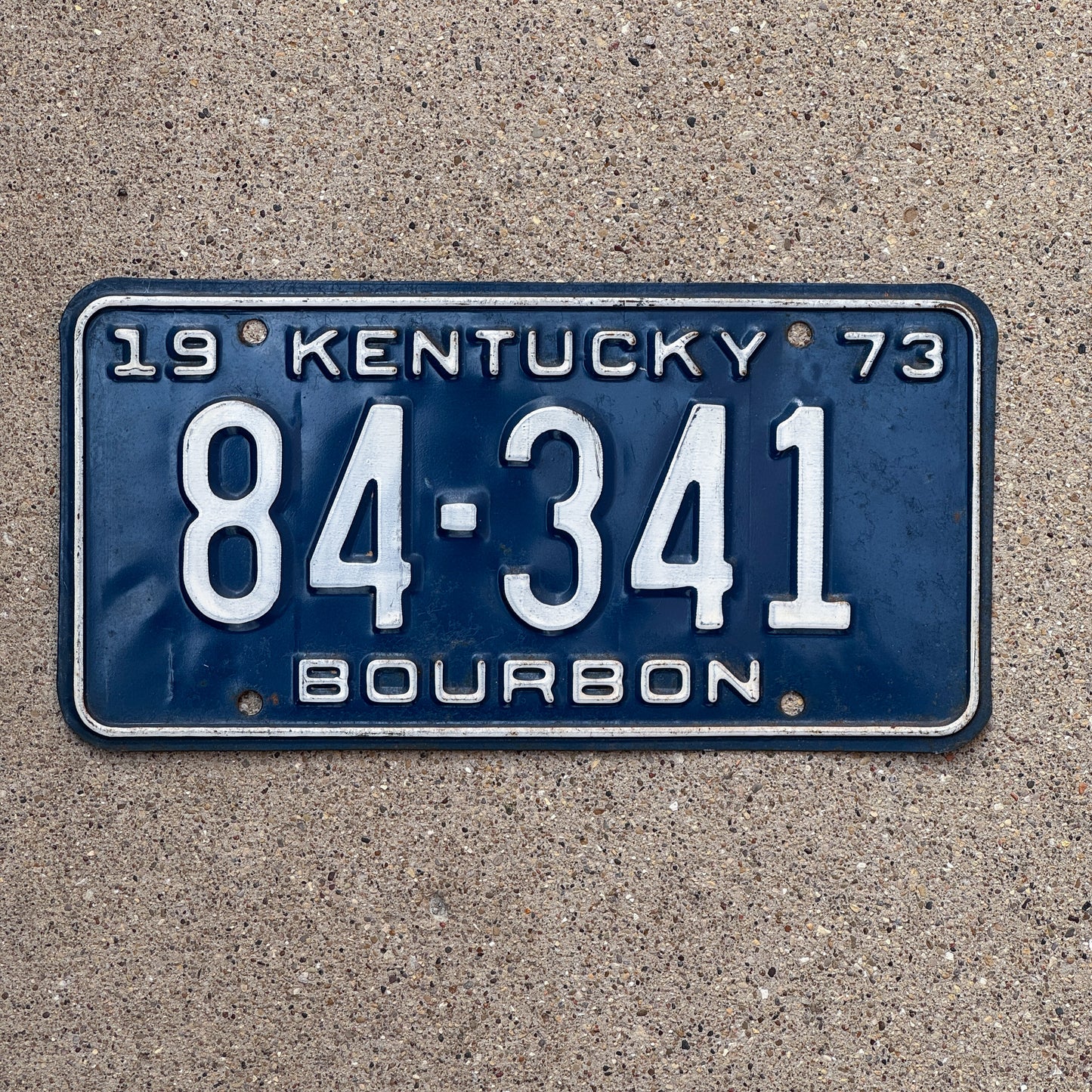 Photo of a 1973 Kentucky License Plate Auto Tag Garage Decor Vintage Bourbon County Whiskey 84 341 with original patina