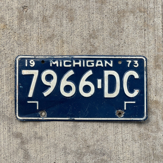 Photo of a 1973 Michigan Commercial License Plate Auto Tag Garage Decor Vintage 7966 DC with original patina