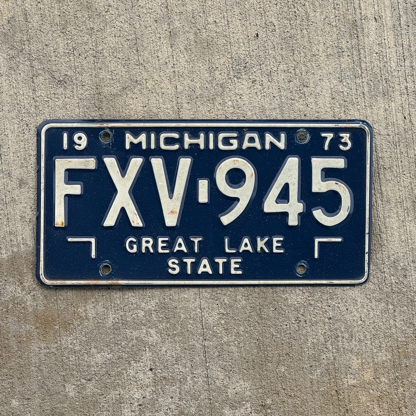 Photo of a 1973 Michigan License Plate Auto Tag Garage Decor Vintage FXV 945 with original patina