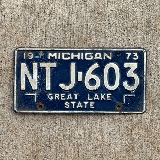 Photo of a 1973 Michigan License Plate Auto Tag Garage Decor Vintage NTJ 603 with original patina