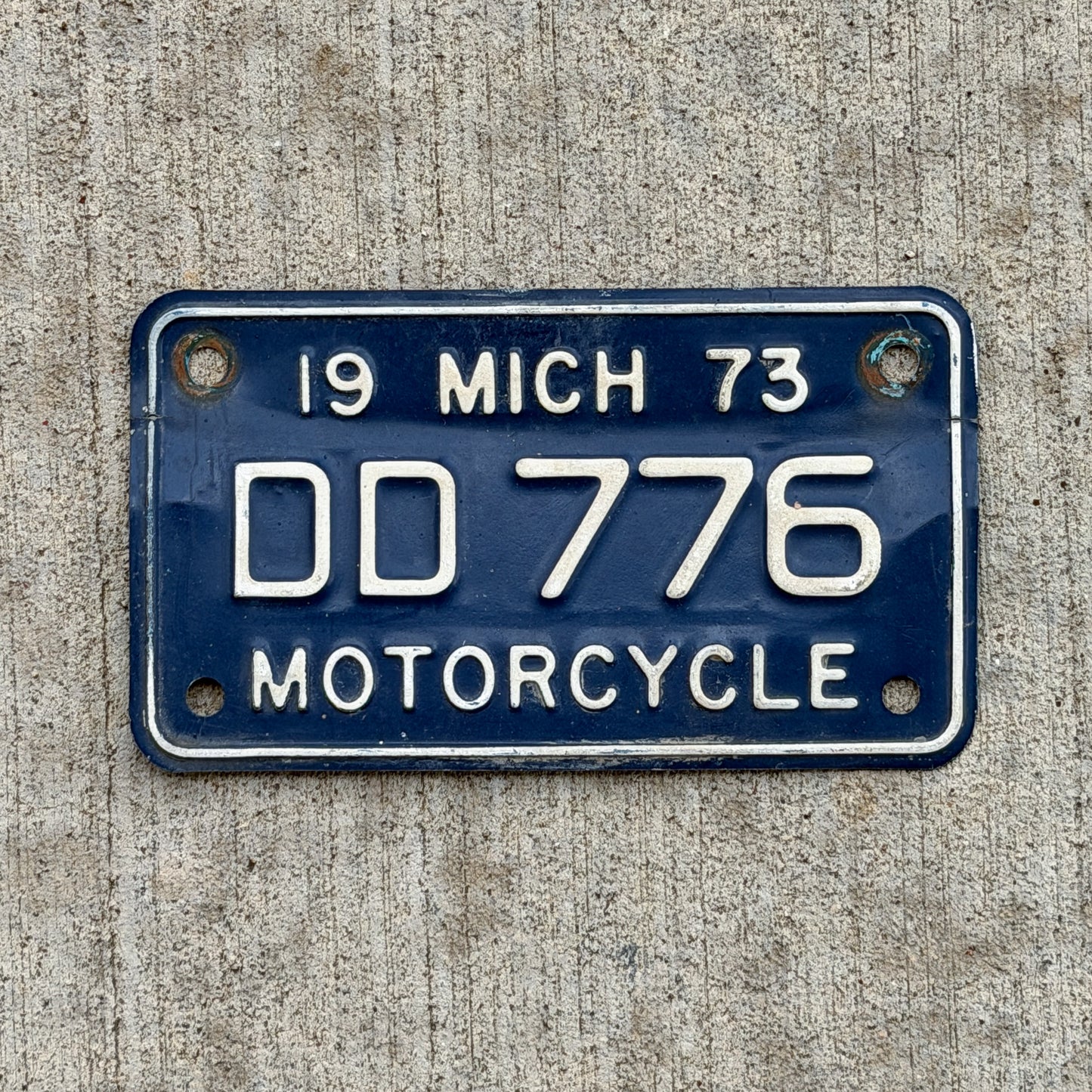 Photo of a 1973 Michigan Motorcycle License Plate Auto Tag Garage Decor Vintage DD 776 with original patina