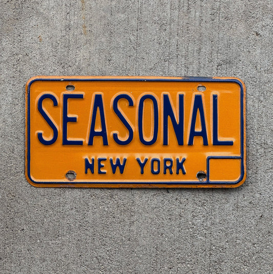Photo of a 1973 New York Vanity License Plate Auto Tag Garage Decor Vintage Seasons Fall Spring Summer Winter SEASONAL with original patina