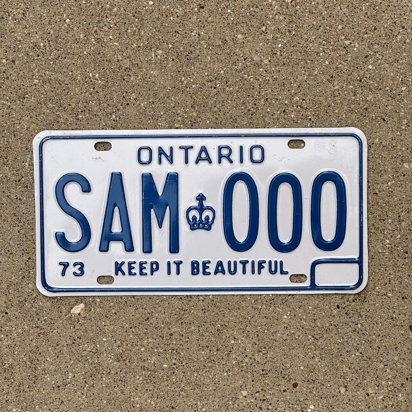 Photo of a 1973 Ontario SAMPLE License Plate Auto Tag Garage Decor Vintage SAM 000