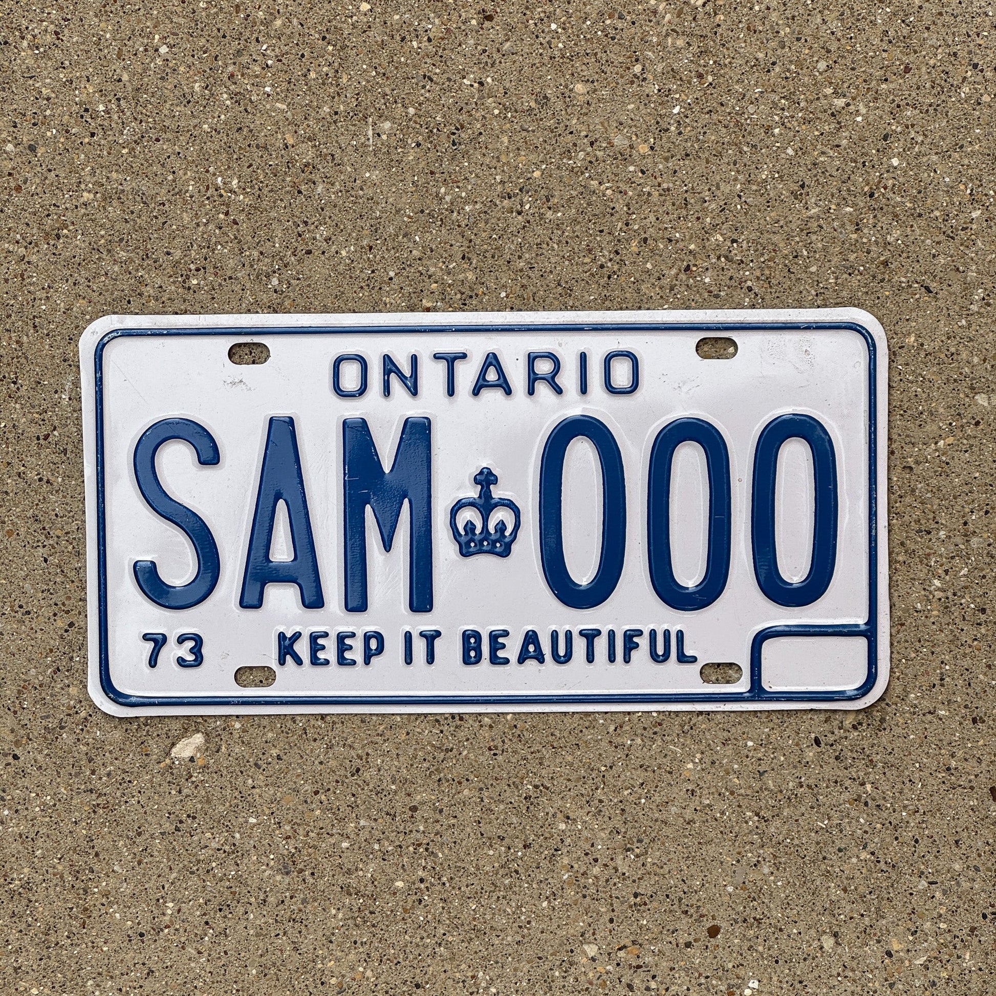 Photo of a 1973 Ontario SAMPLE License Plate Auto Tag Garage Decor Vintage SAM 000