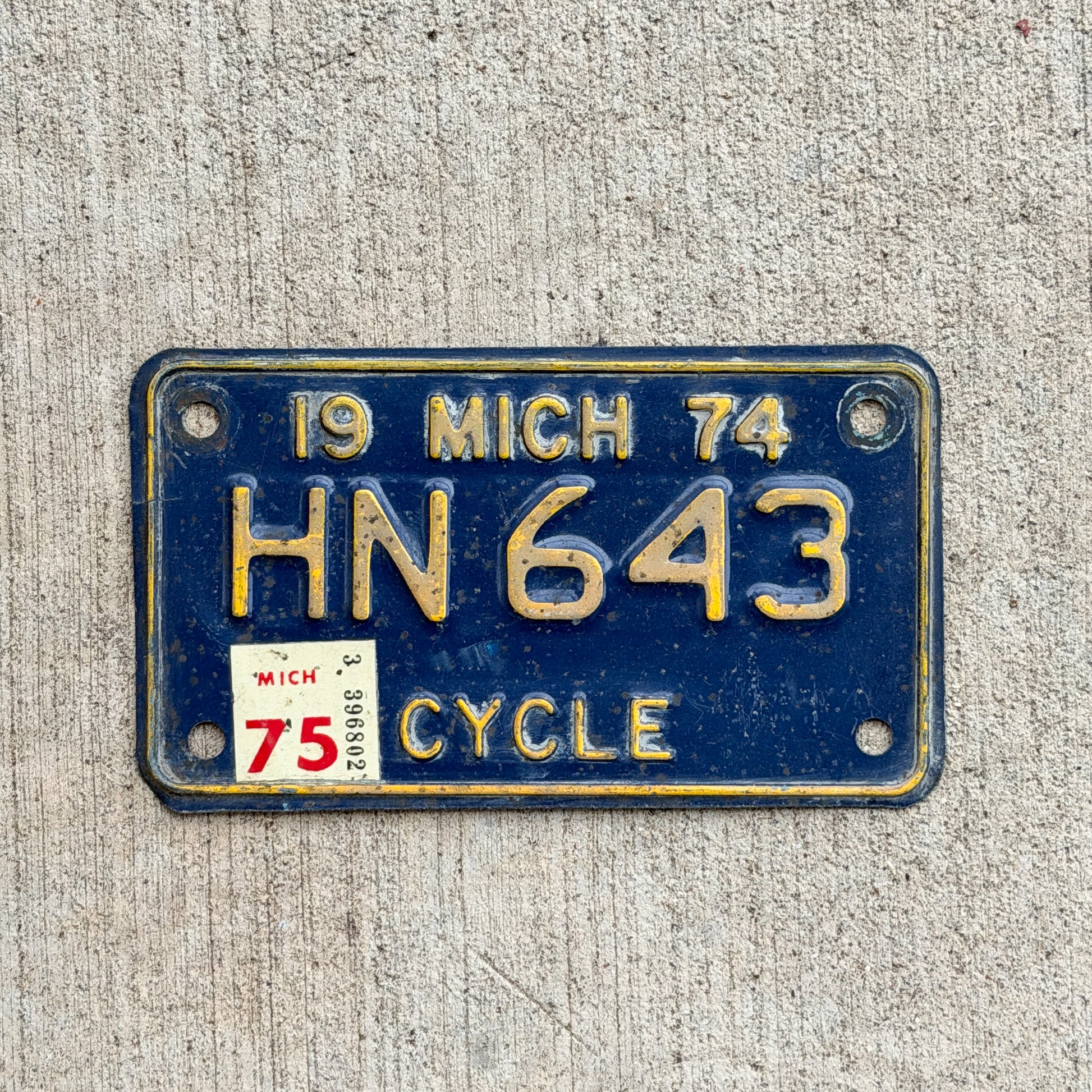 Photo of a 1974 1975 Michigan Motorcycle License Plate Auto Tag Garage Decor Vintage HN 643 with original patina