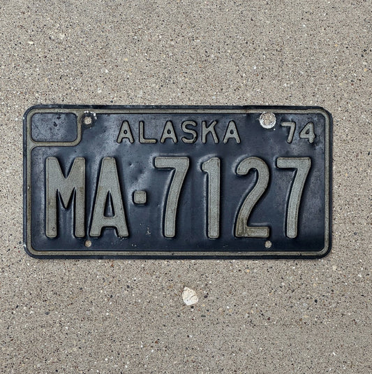 Photo of a 1974 Alaska Truck License Plate Auto Tag Garage Decor Vintage Black MA 7127 with original patina