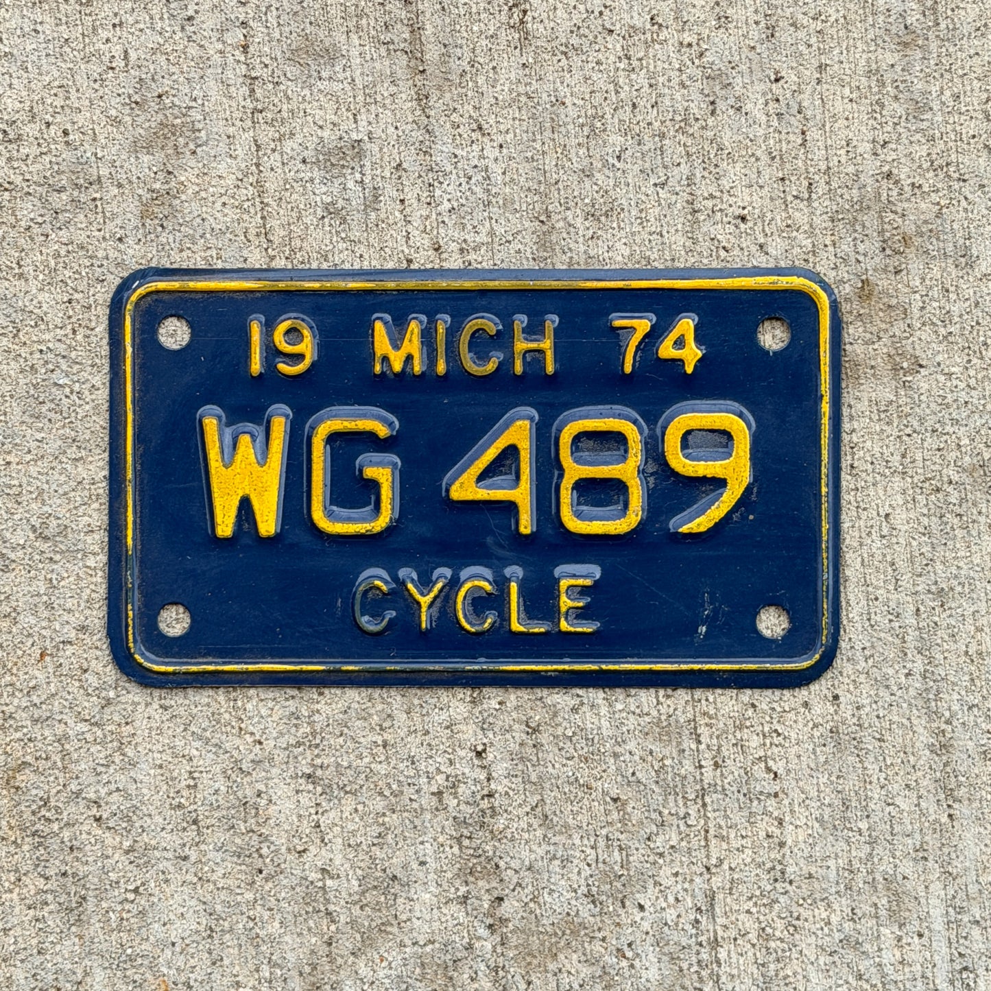 Photo of a 1974 Michigan Motorcycle License Plate Auto Tag Garage Decor Vintage WG 489 with original patina