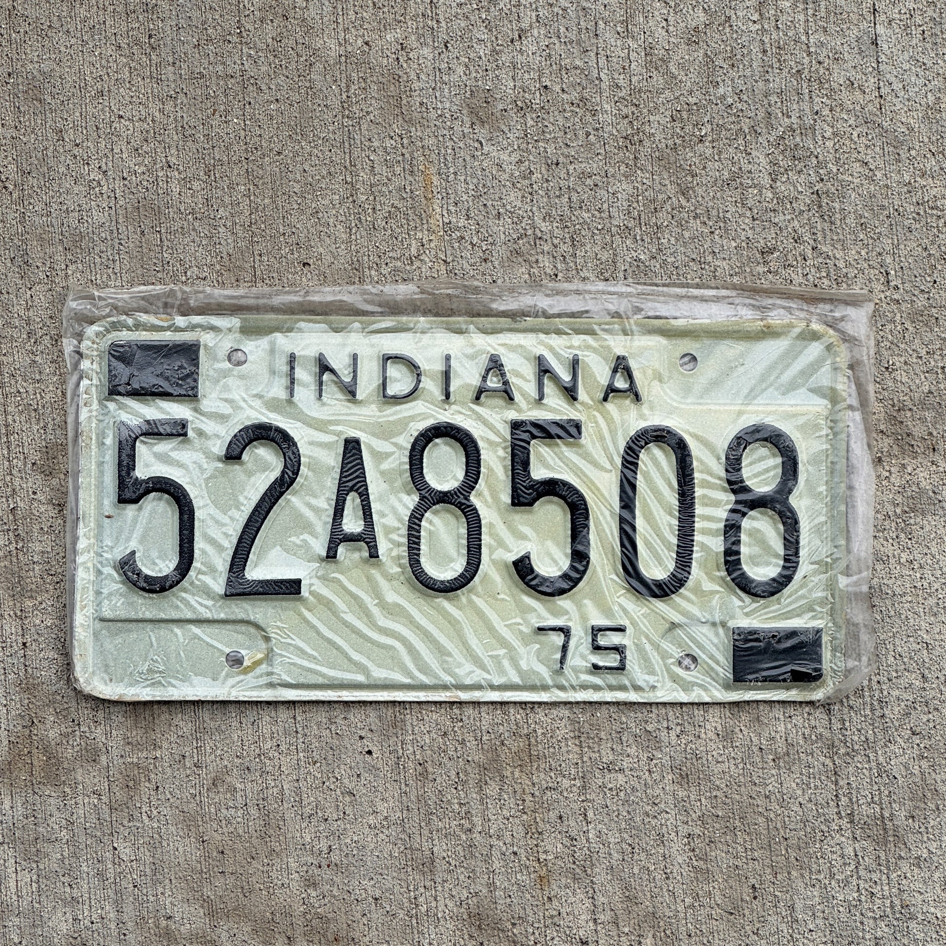 Photo of a 1975 Indiana License Plate Auto Tag Garage Decor Vintage New Old Stock 52 A 8508 with original patina