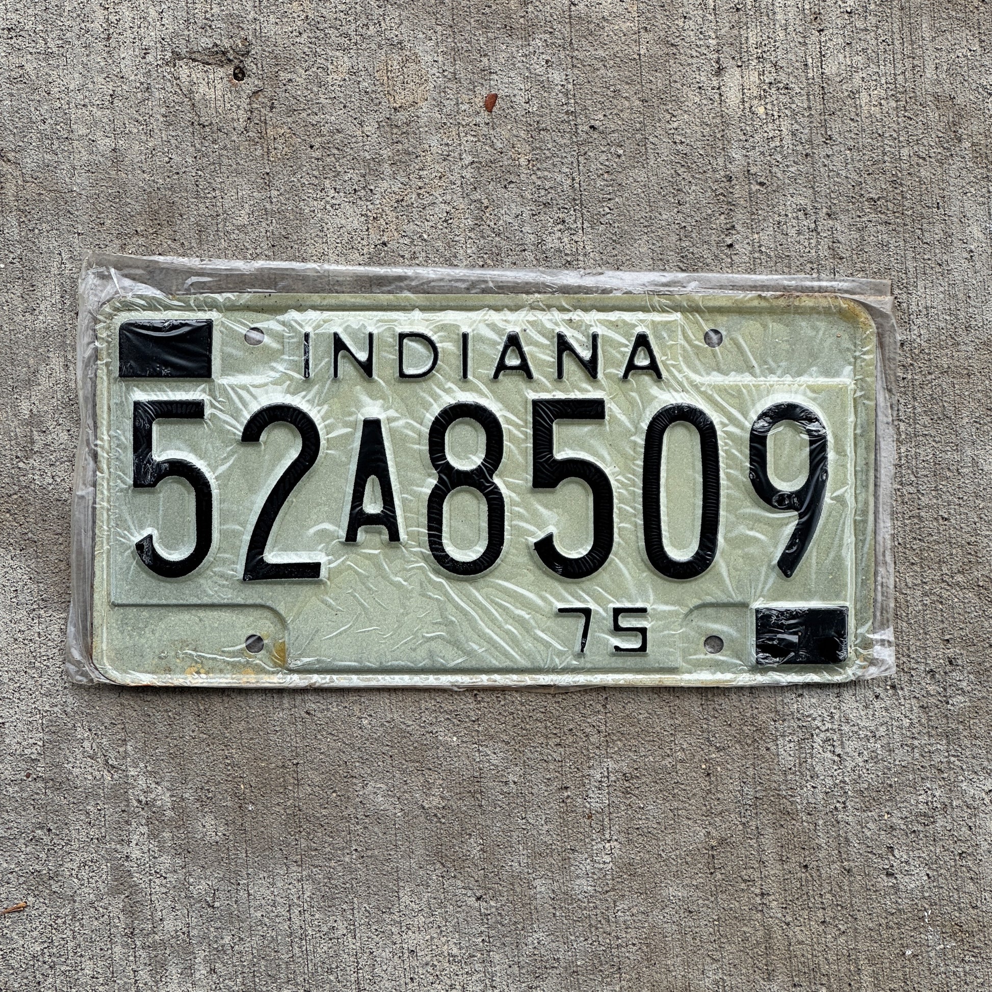 Photo of a 1975 Indiana License Plate Auto Tag Garage Decor Vintage New Old Stock 52 A 8509 with original patina