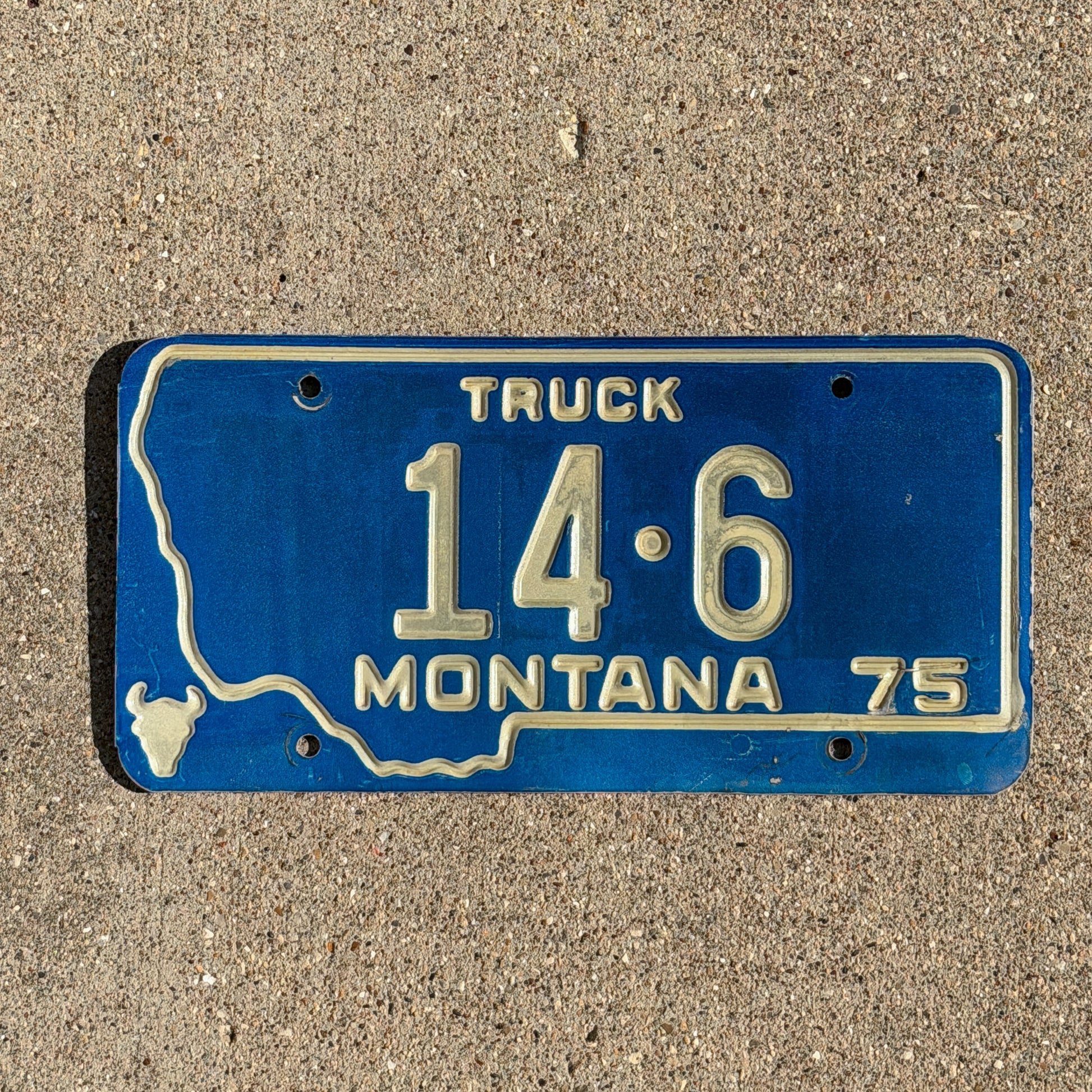 Photo of a 1975 Montana Truck License Plate Auto Tag Garage Decor Vintage State Shape Low Number Two Digit Custer County 14 6 with original patina