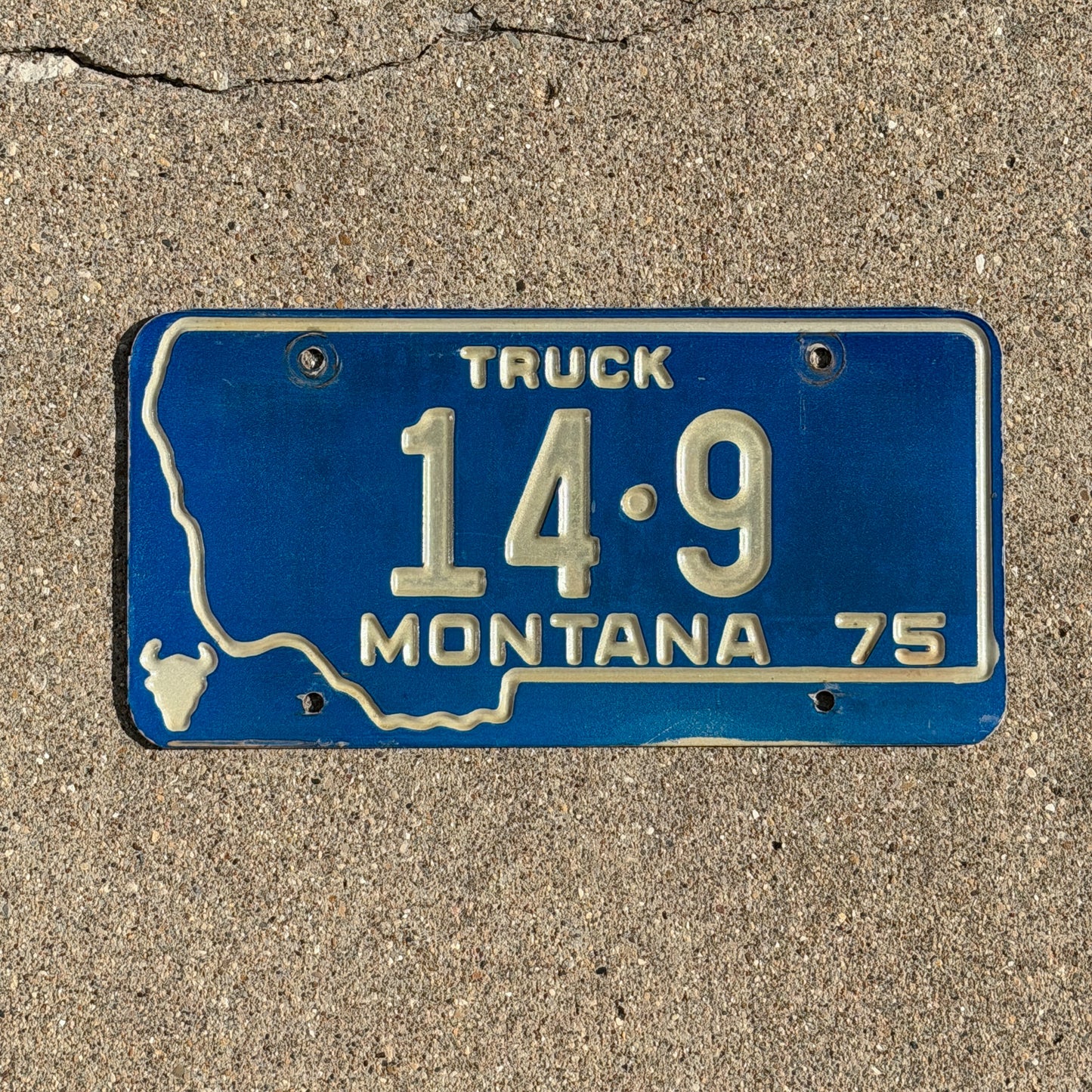 Photo of a 1975 Montana Truck License Plate Auto Tag Garage Decor Vintage State Shape Low Number Two Digit Custer County 14 9 with original patina