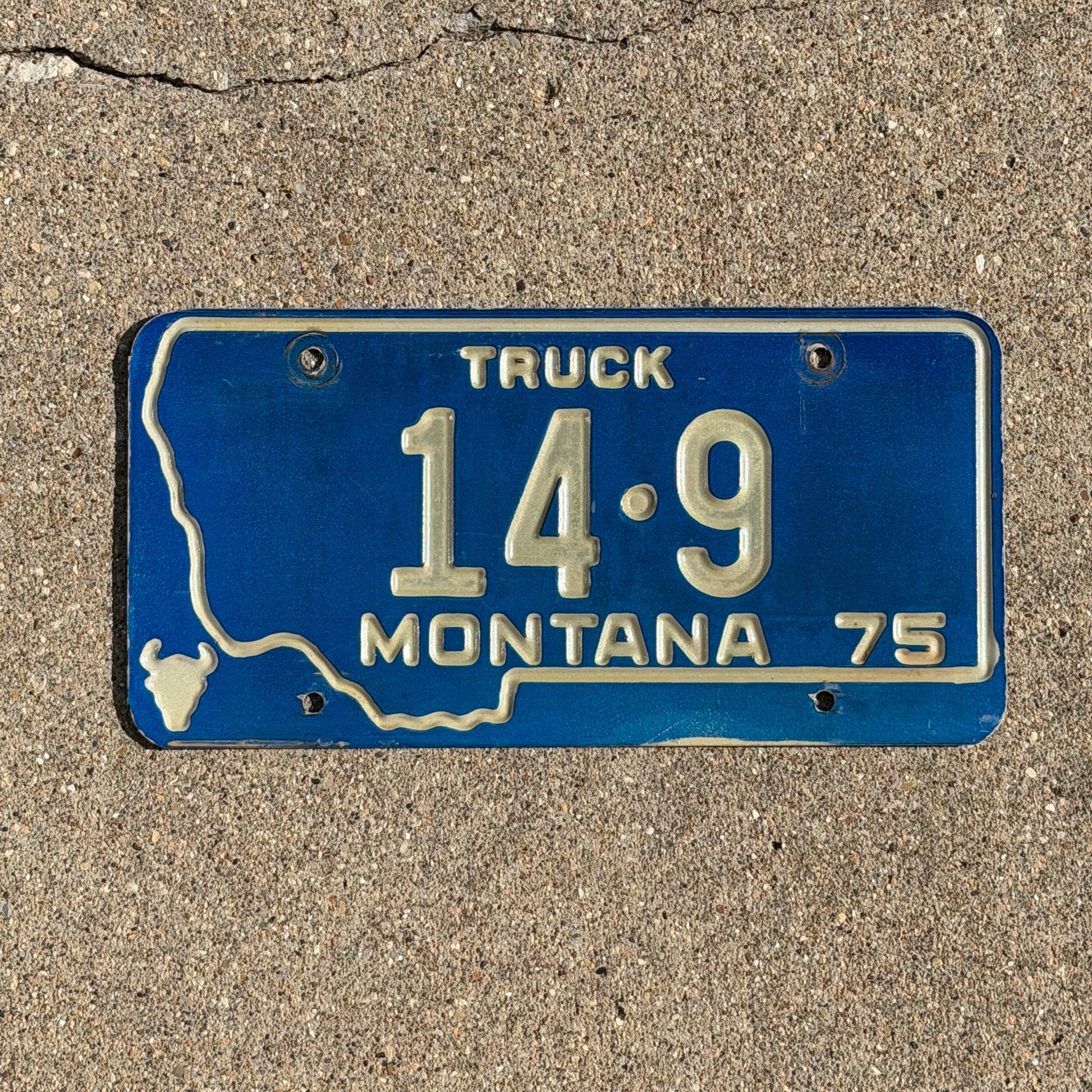 Photo of a 1975 Montana Truck License Plate Auto Tag Garage Decor Vintage State Shape Low Number Two Digit Custer County 14 9 with original patina