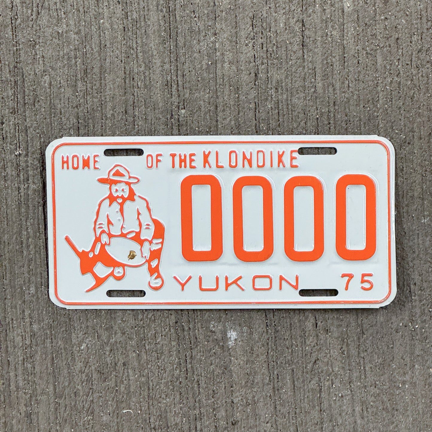 Photo of a 1975 Yukon Sample License Plate Auto Tag Garage Decor Vintage Prospector Graphic 0000 with original patina