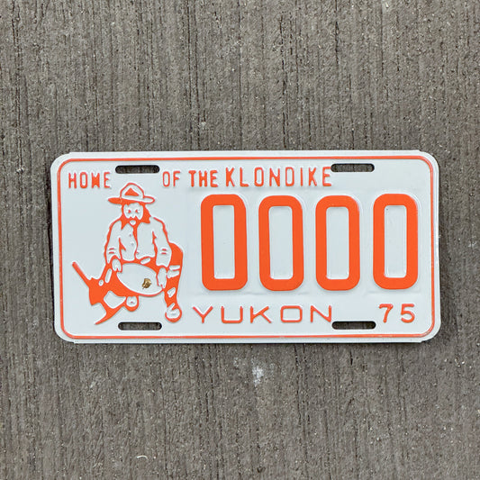 Photo of a 1975 Yukon Sample License Plate Auto Tag Garage Decor Vintage Prospector Graphic 0000 with original patina