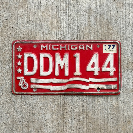 Photo of a 1976 1977 Michigan Error License Plate Auto Tag Garage Decor Vintage Bicentennial Misprint Lacking Blue DDM 144 with original patina