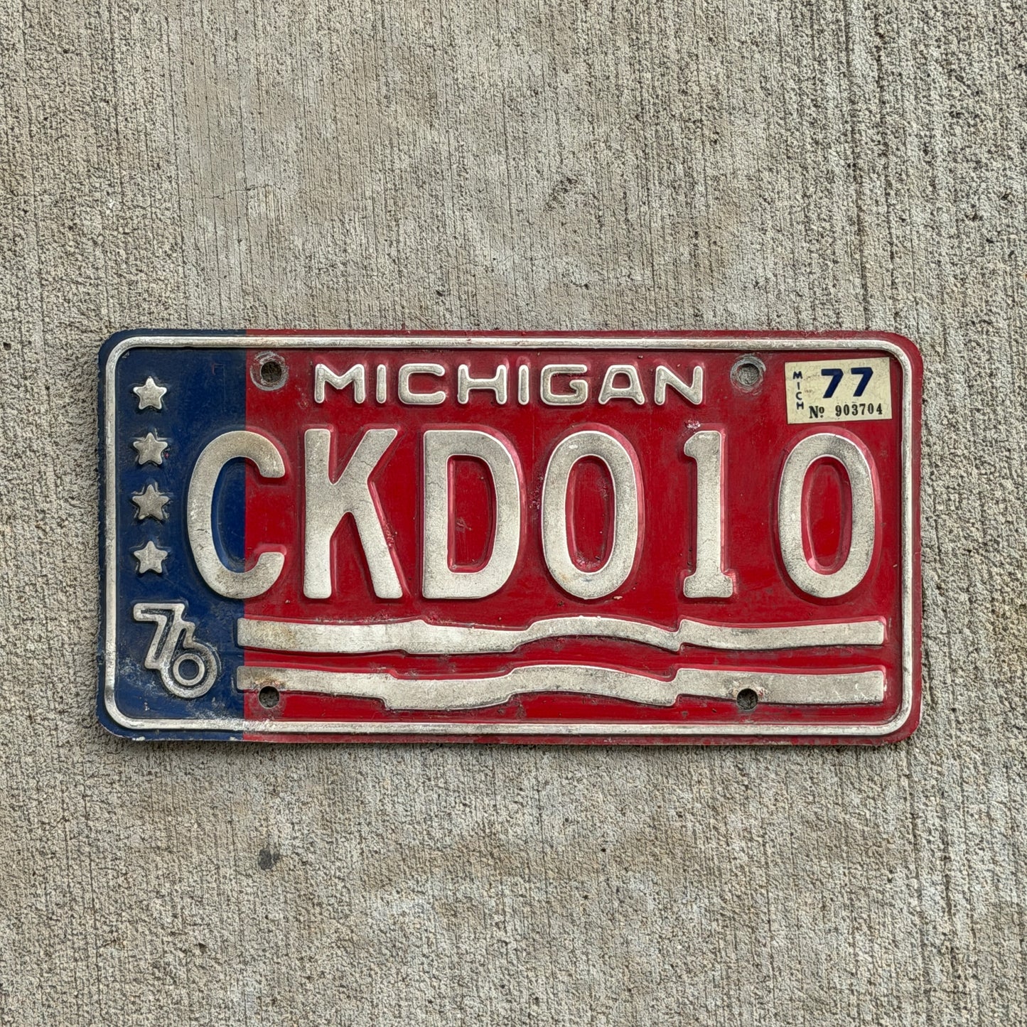 Photo of a 1976 1977 Michigan License Plate Auto Tag Garage Decor Vintage Bicentennial CKD 010 with original patina
