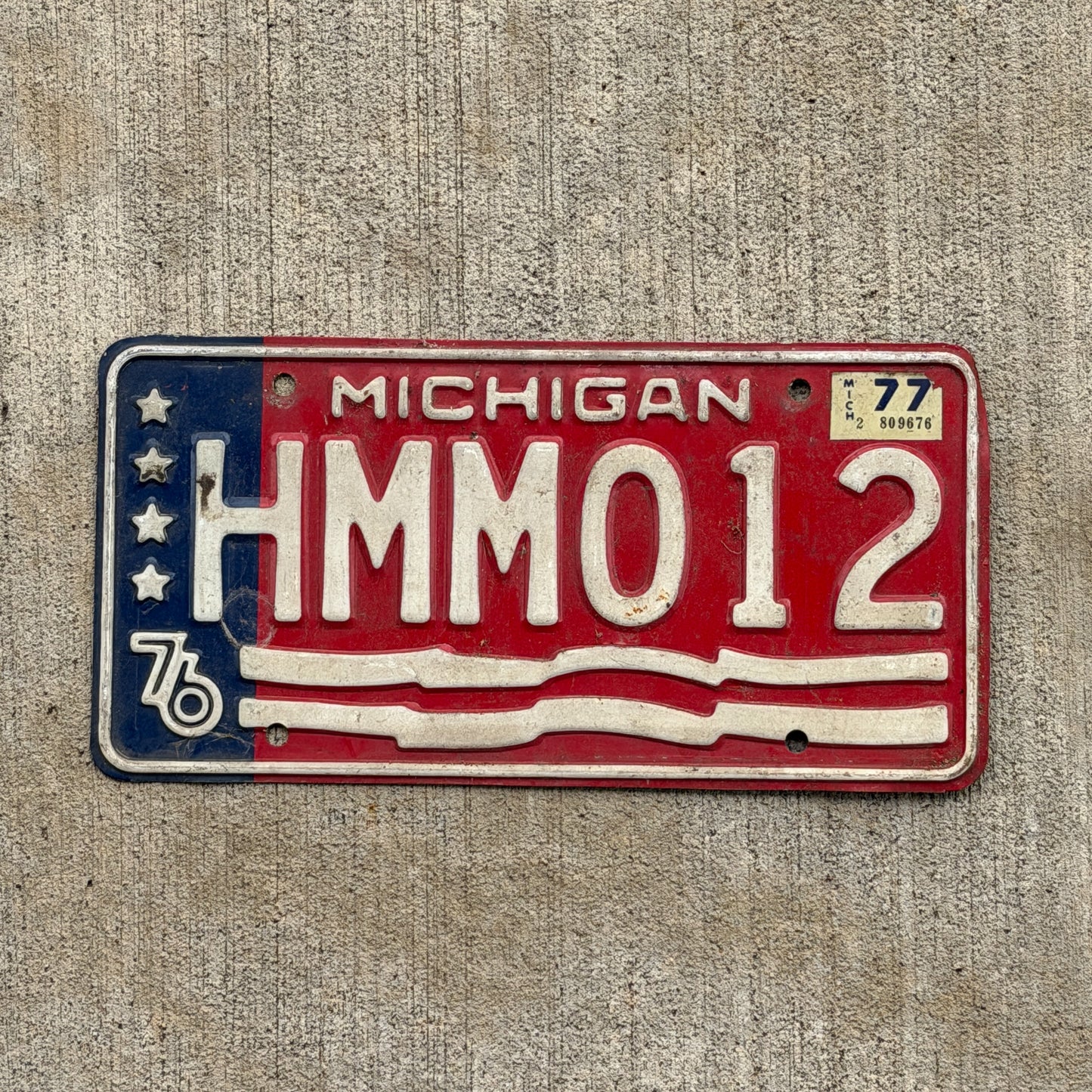 Photo of a 1976 1977 Michigan License Plate Auto Tag Garage Decor Vintage Bicentennial HMM 012 with original patina