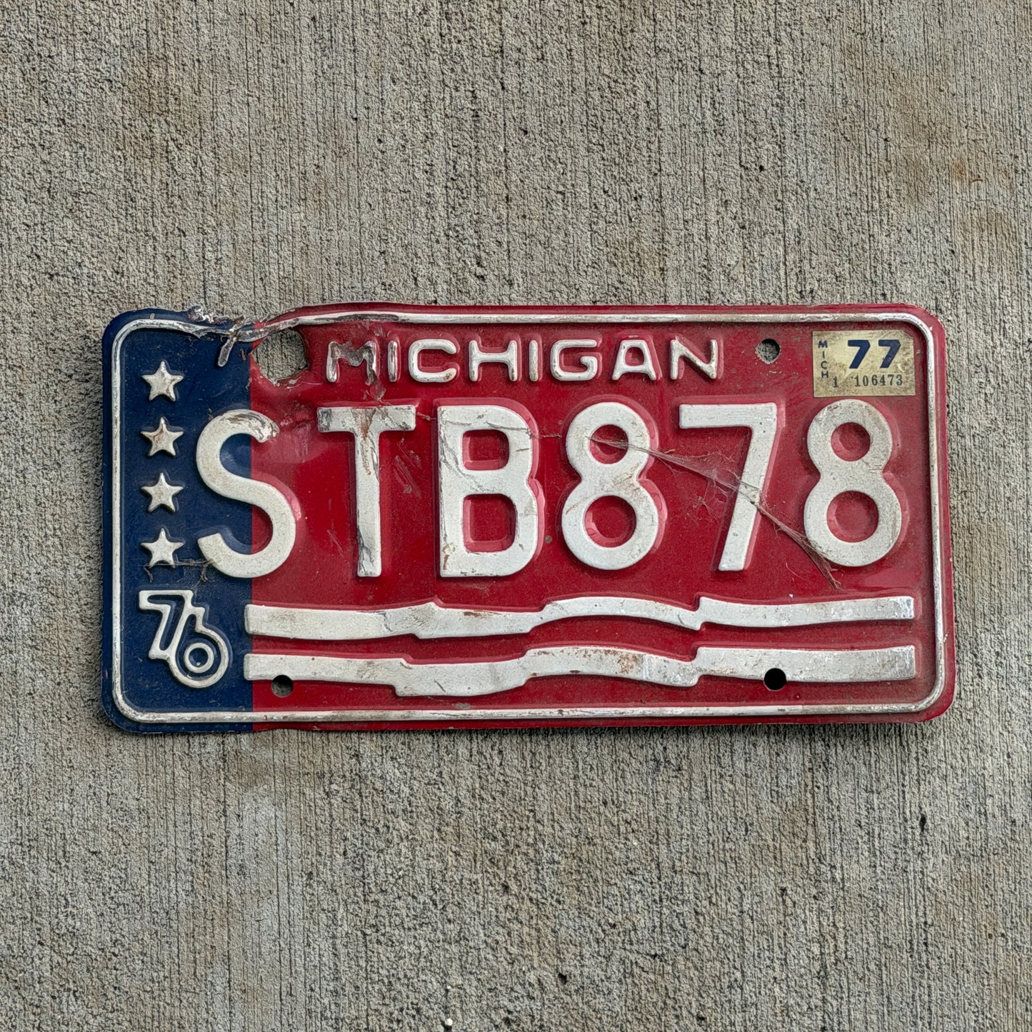 Photo of a 1976 1977 Michigan License Plate Auto Tag Garage Decor Vintage Bicentennial STB 878 with original patina