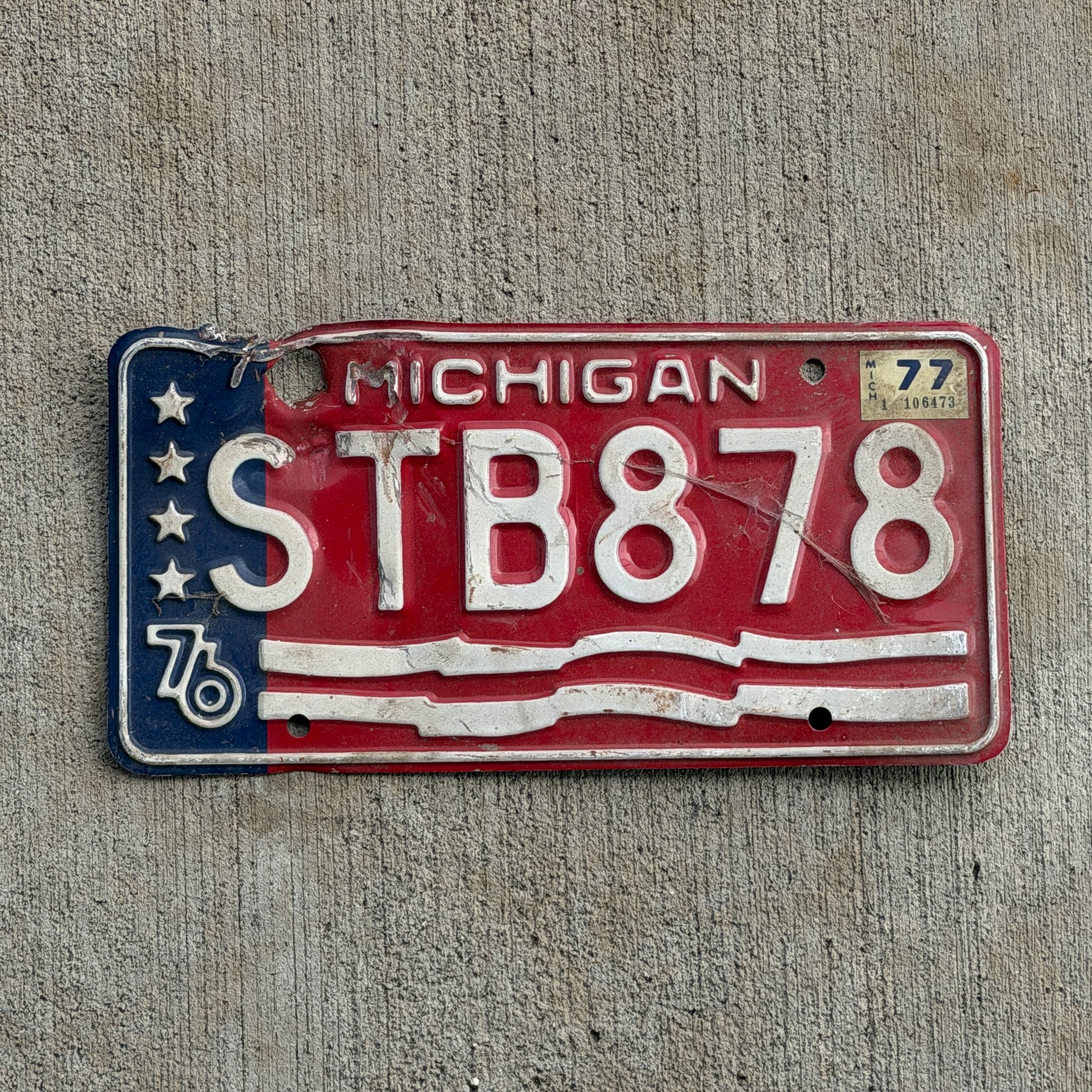 Photo of a 1976 1977 Michigan License Plate Auto Tag Garage Decor Vintage Bicentennial STB 878 with original patina