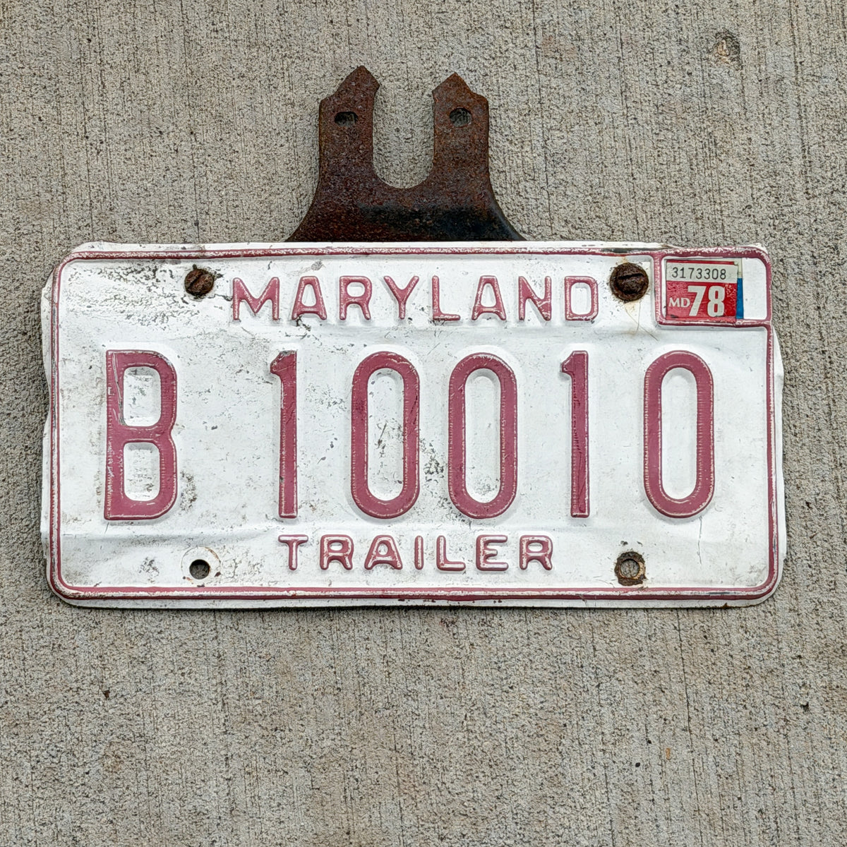 Photo of a 1976 1978 Maryland Trailer License Plate Auto Tag Garage Decor Vintage With Mount Nice Number B 10010 with original patina