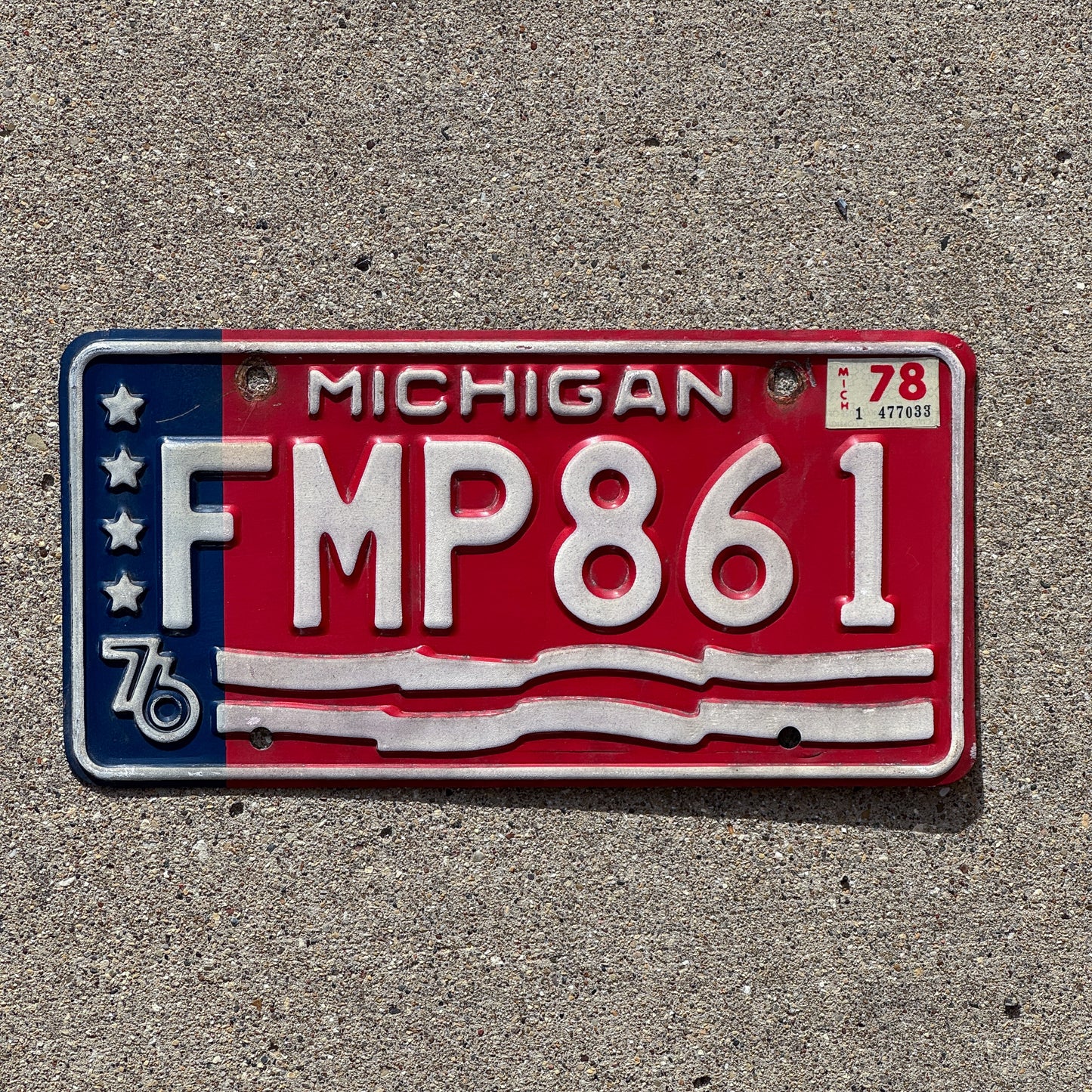 Photo of a 1976 1978 Michigan License Plate Auto Tag 1 Vintage Garage American Flag Bicentennial FMP 861 with original patina
