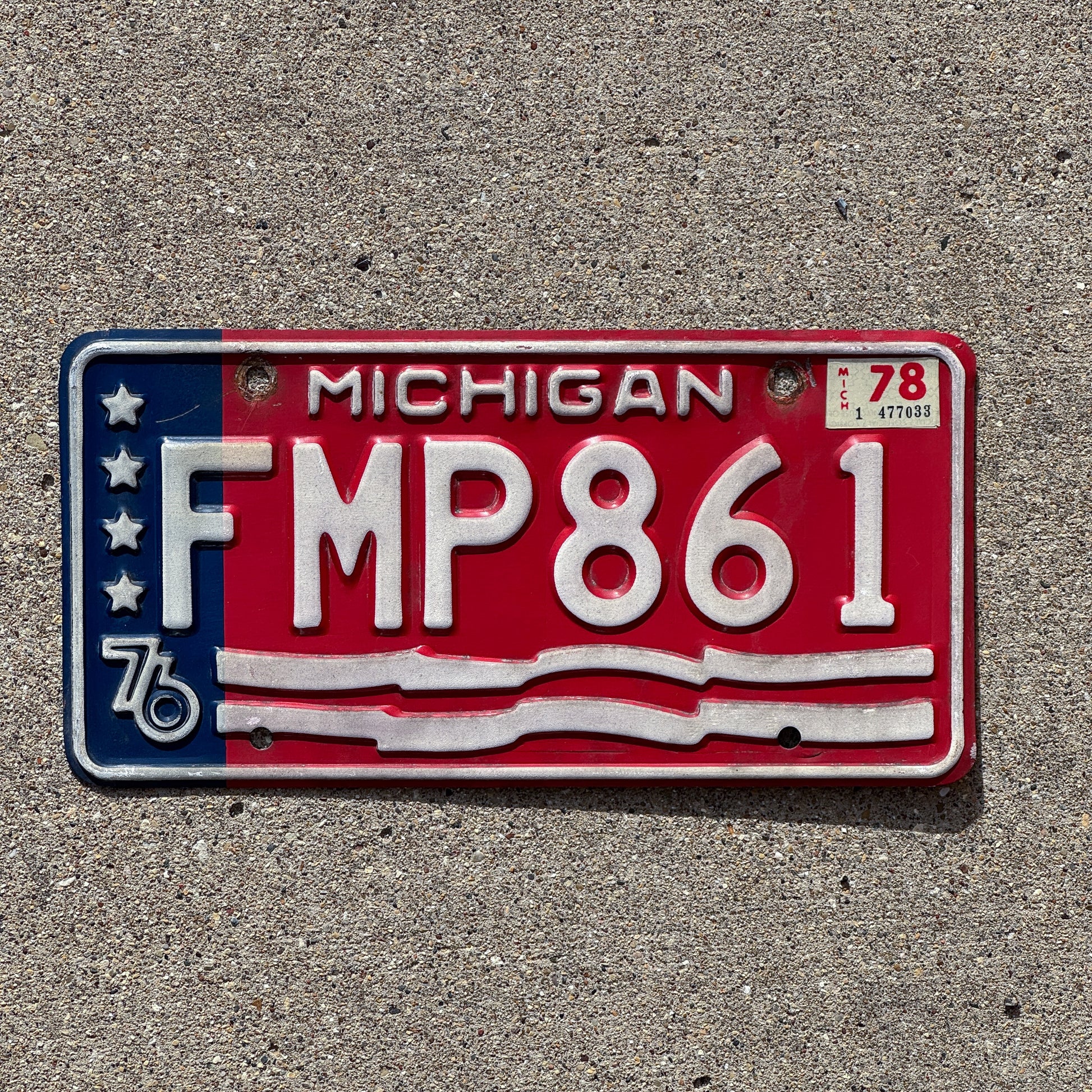Photo of a 1976 1978 Michigan License Plate Auto Tag 1 Vintage Garage American Flag Bicentennial FMP 861 with original patina