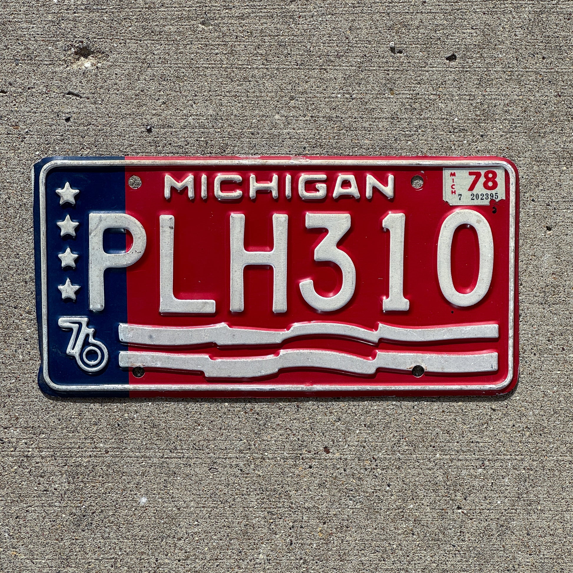 Photo of a 1976 1978 Michigan License Plate Auto Tag Garage Decor Vintage American Flag Bicentennial PLH 310 with original patina