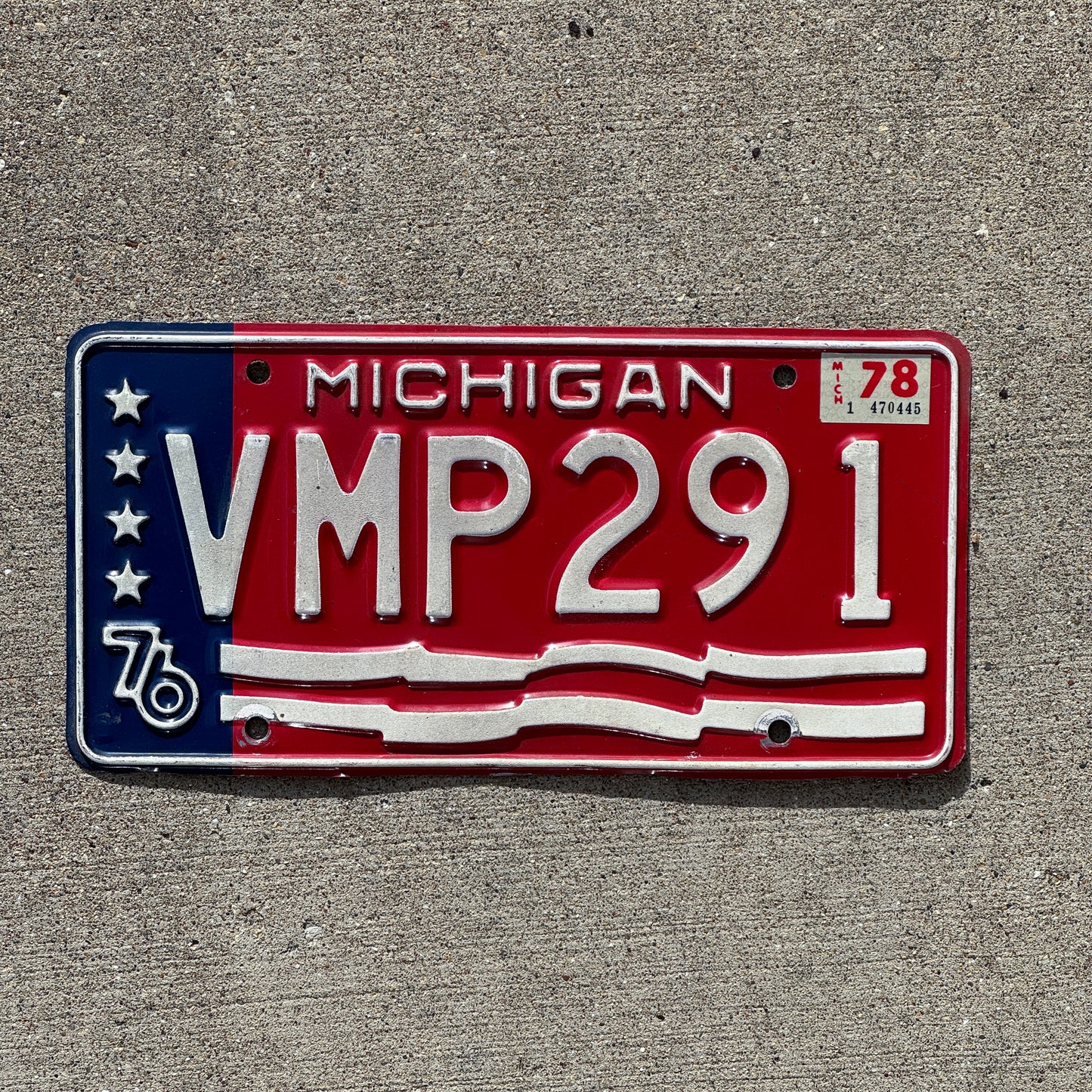 Photo of a 1976 1978 Michigan License Plate Auto Tag Garage Decor Vintage American Flag Bicentennial VMP 291 with original patina