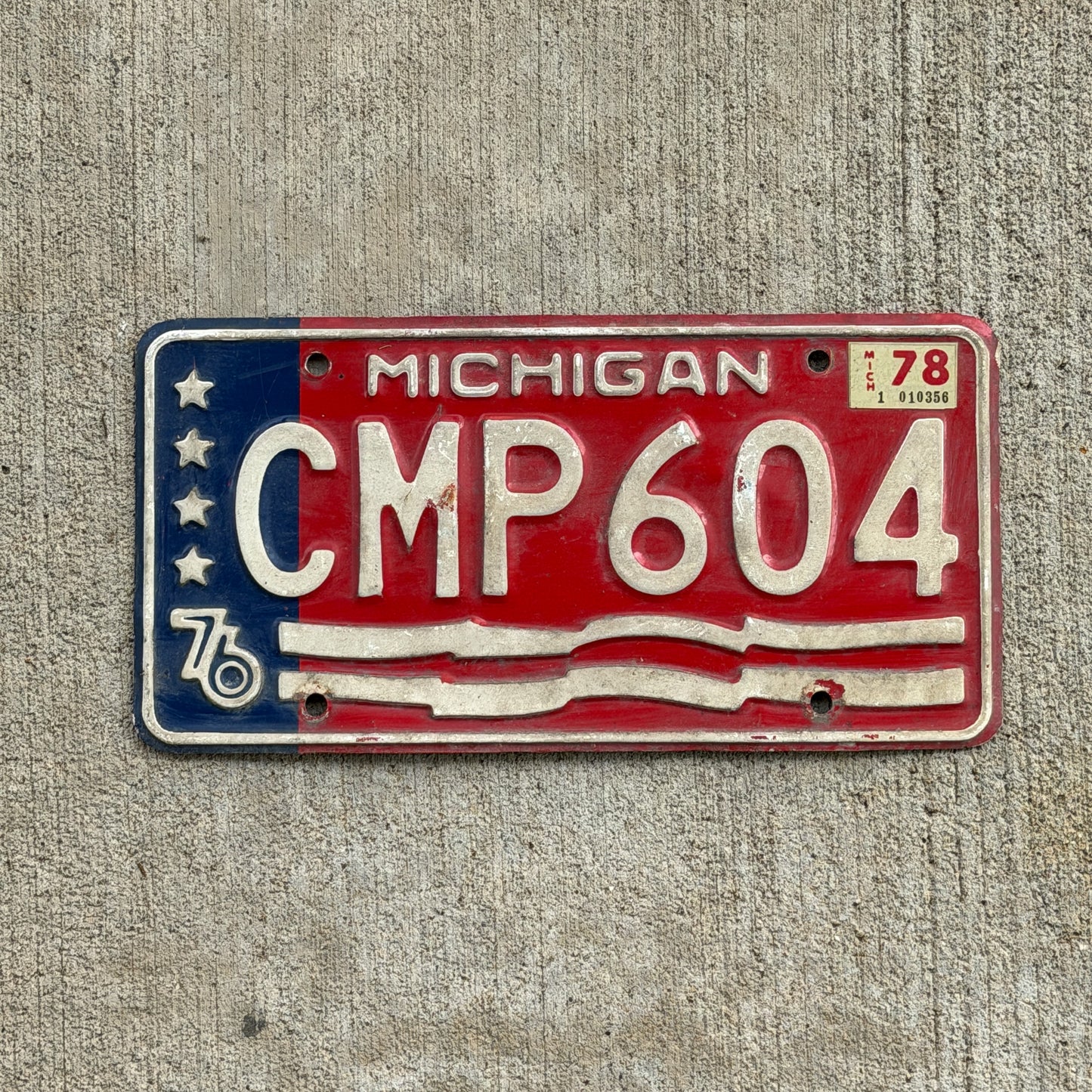 Photo of a 1976 1978 Michigan License Plate Auto Tag Garage Decor Vintage Bicentennial CMP 604 with original patina