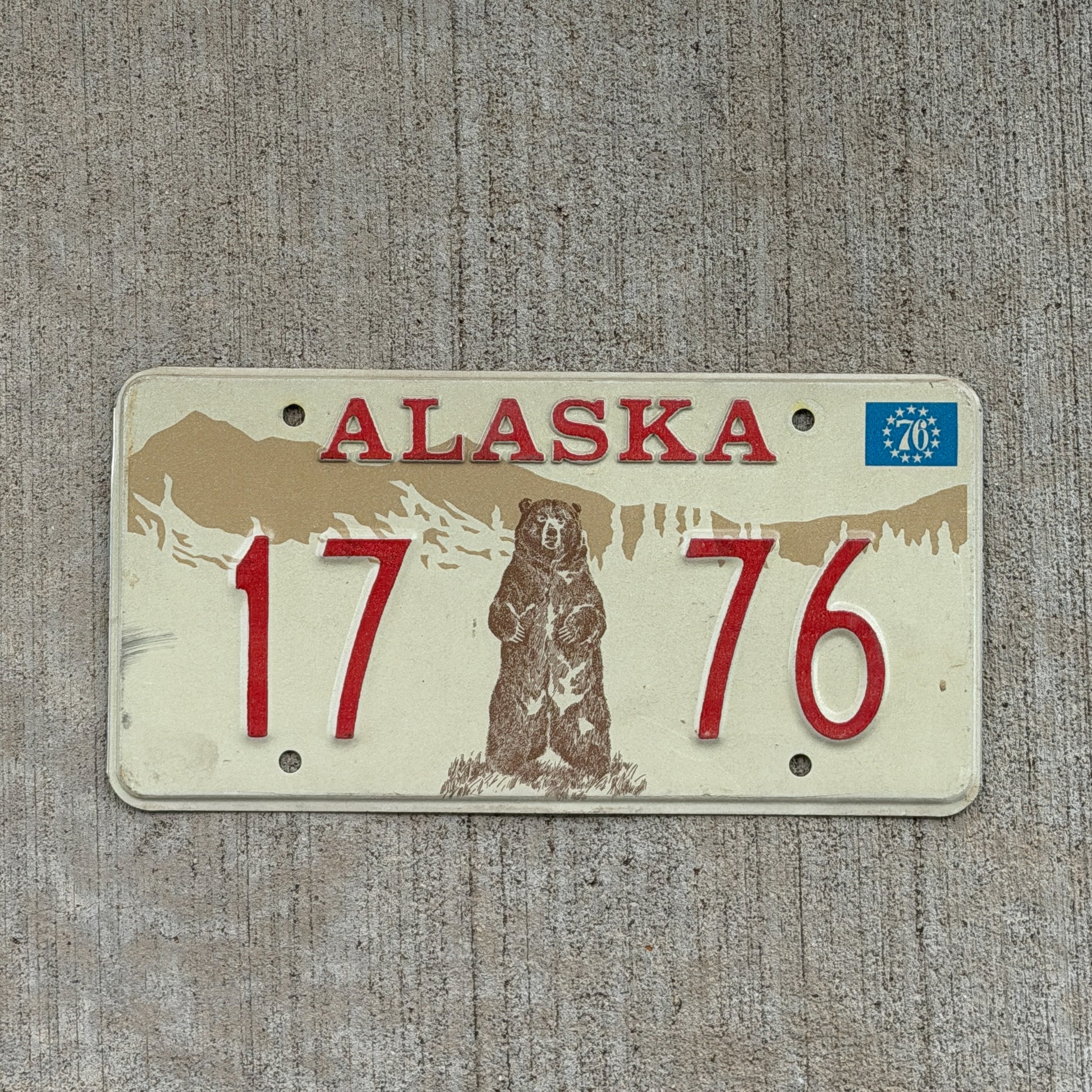 Photo of a 1976 Alaska Sample License Plate Auto Tag Garage Decor Vintage Bicentennial Bear 17 76 with original patina