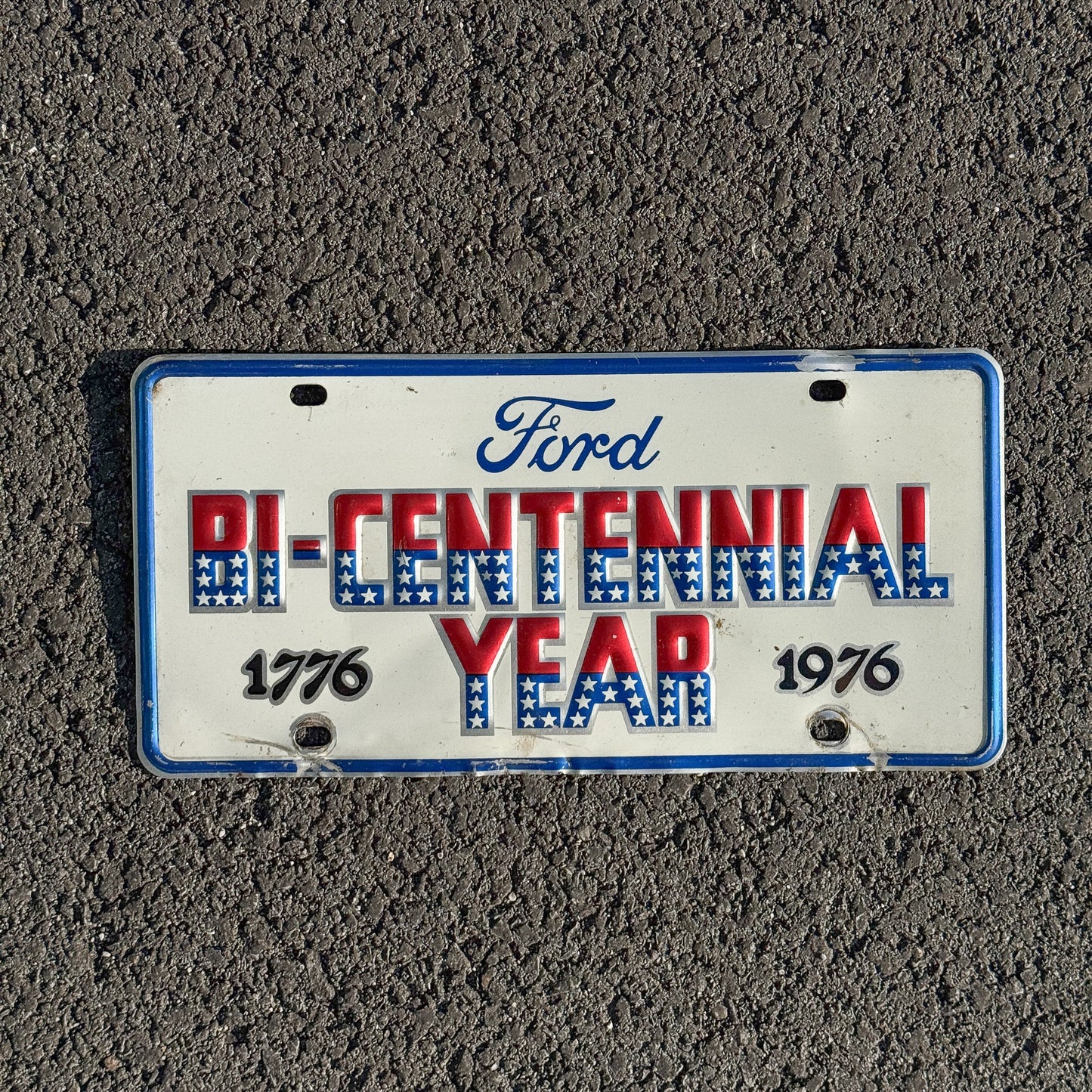 Photo of a 1976 Booster License Plate Auto Tag Garage Decor Vintage Ford Bicentennial Year Metal