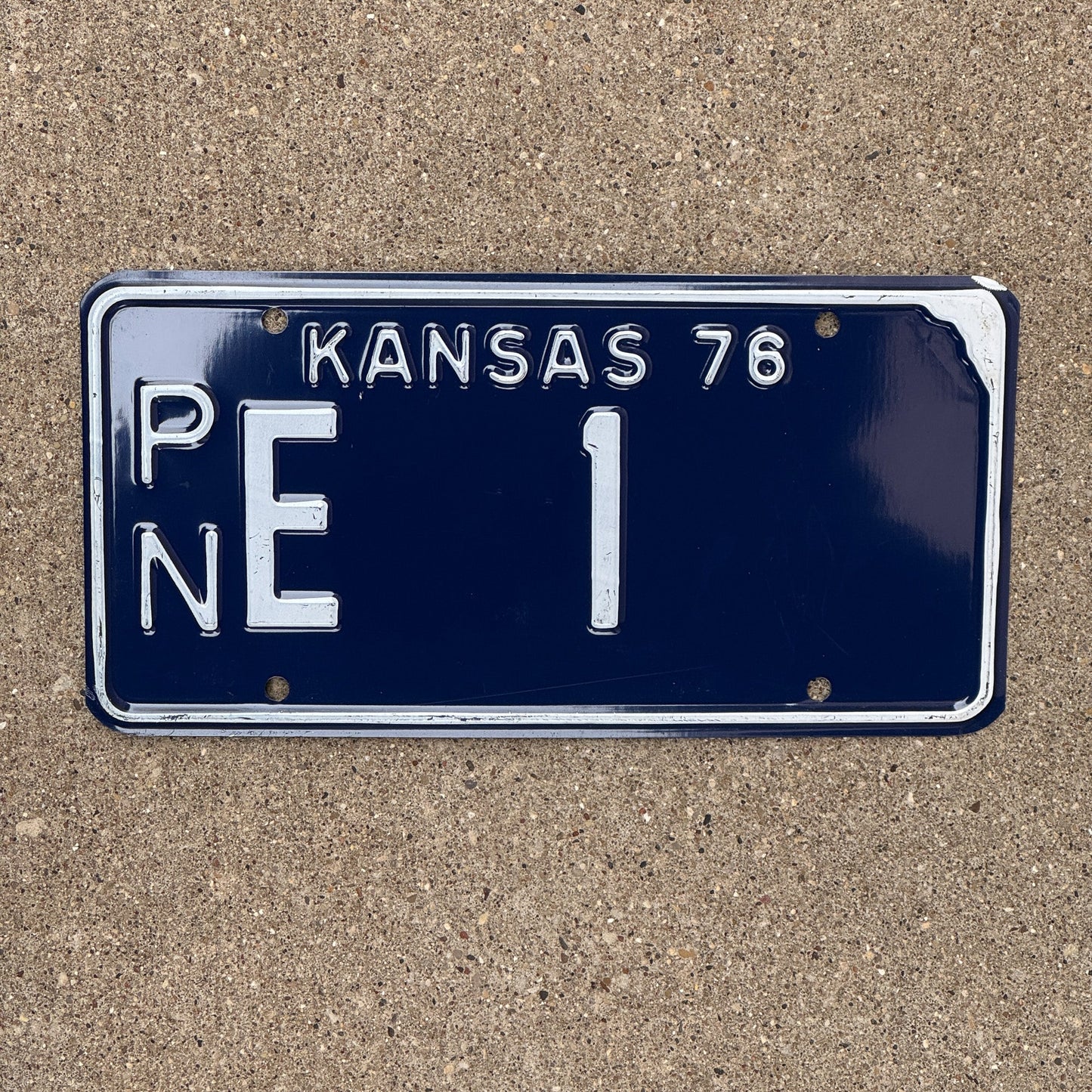 Photo of a 1976 Kansas License Plate Auto Tag Garage Decor Vintage Number One Low Number PN E 1 with original patina