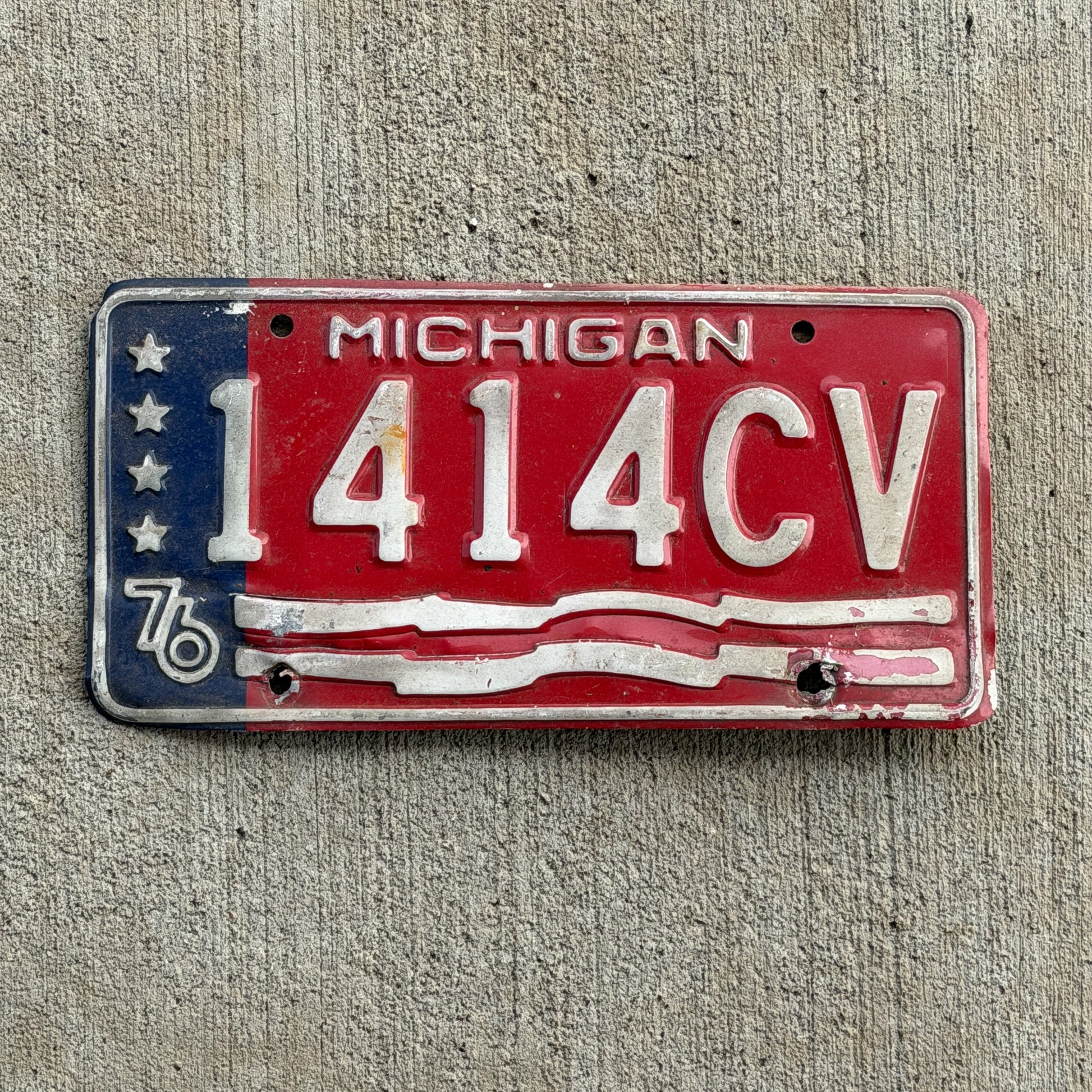 Photo of a 1976 Michigan Commercial License Plate Auto Tag Garage Decor Vintage Bicentennial 1414 CV with original patina