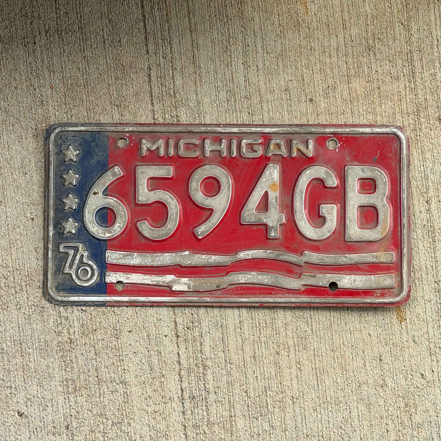 Photo of a 1976 Michigan Commercial License Plate Auto Tag Garage Decor Vintage Bicentennial 6594 GB with original patina