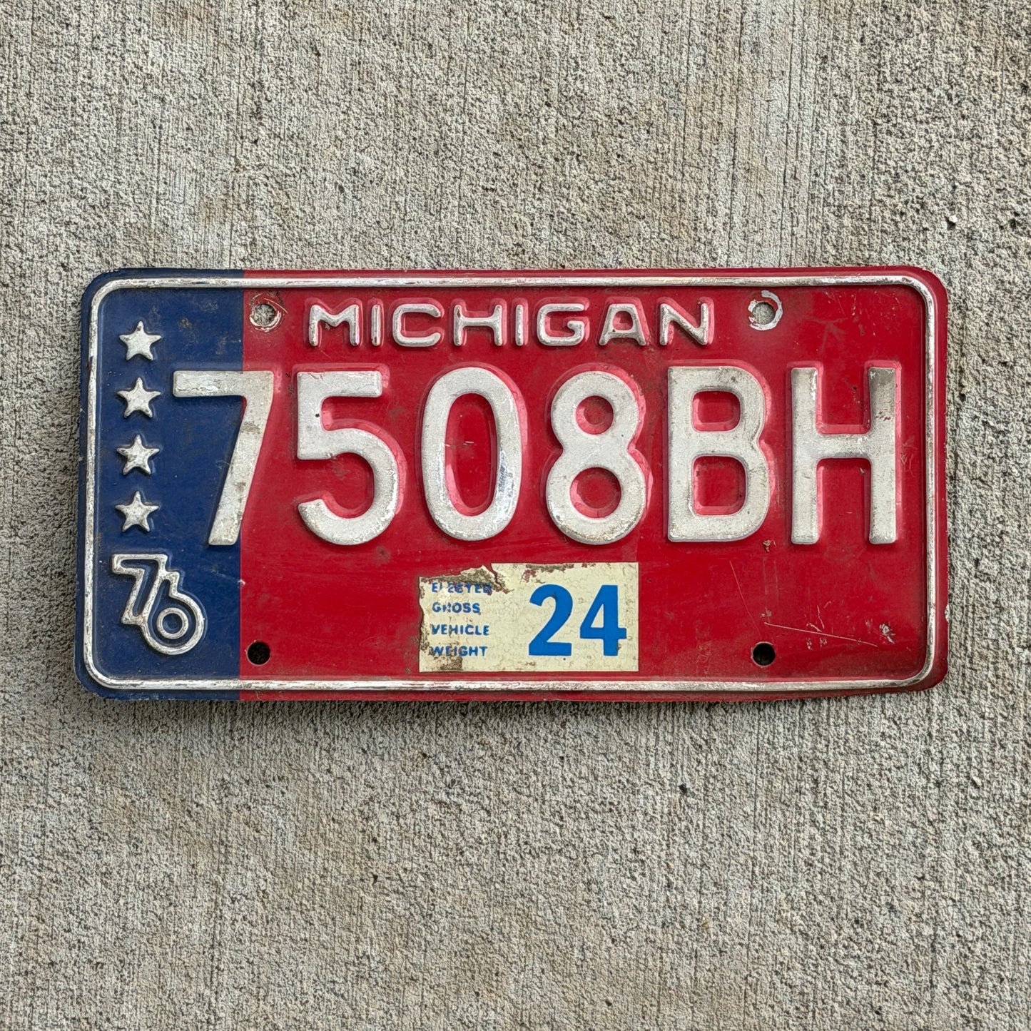 Photo of a 1976 Michigan Commercial License Plate Auto Tag Garage Decor Vintage Heavy Commercial Bicentennial 7508 BH with original patina