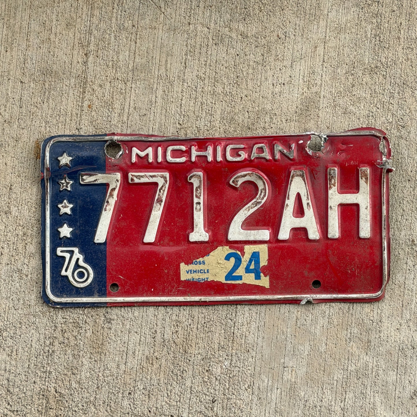 Photo of a 1976 Michigan Commercial License Plate Auto Tag Garage Decor Vintage Heavy Commercial Bicentennial 7712 AH with original patina