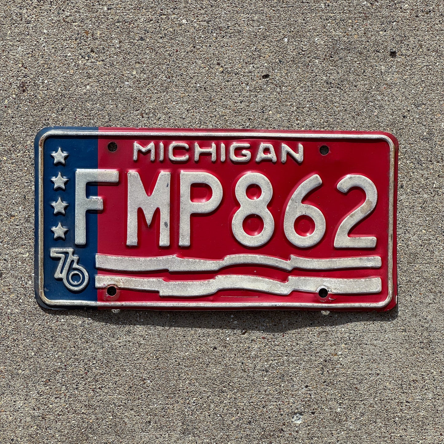 Photo of a 1976 Michigan License Plate Auto Tag 1 Vintage Garage American Flag Bicentennial FMP 862 with original patina