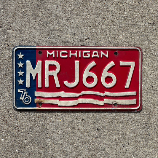 Photo of a 1976 Michigan License Plate Auto Tag Garage Decor Vintage American Flag Bicentennial MRJ 667 with original patina