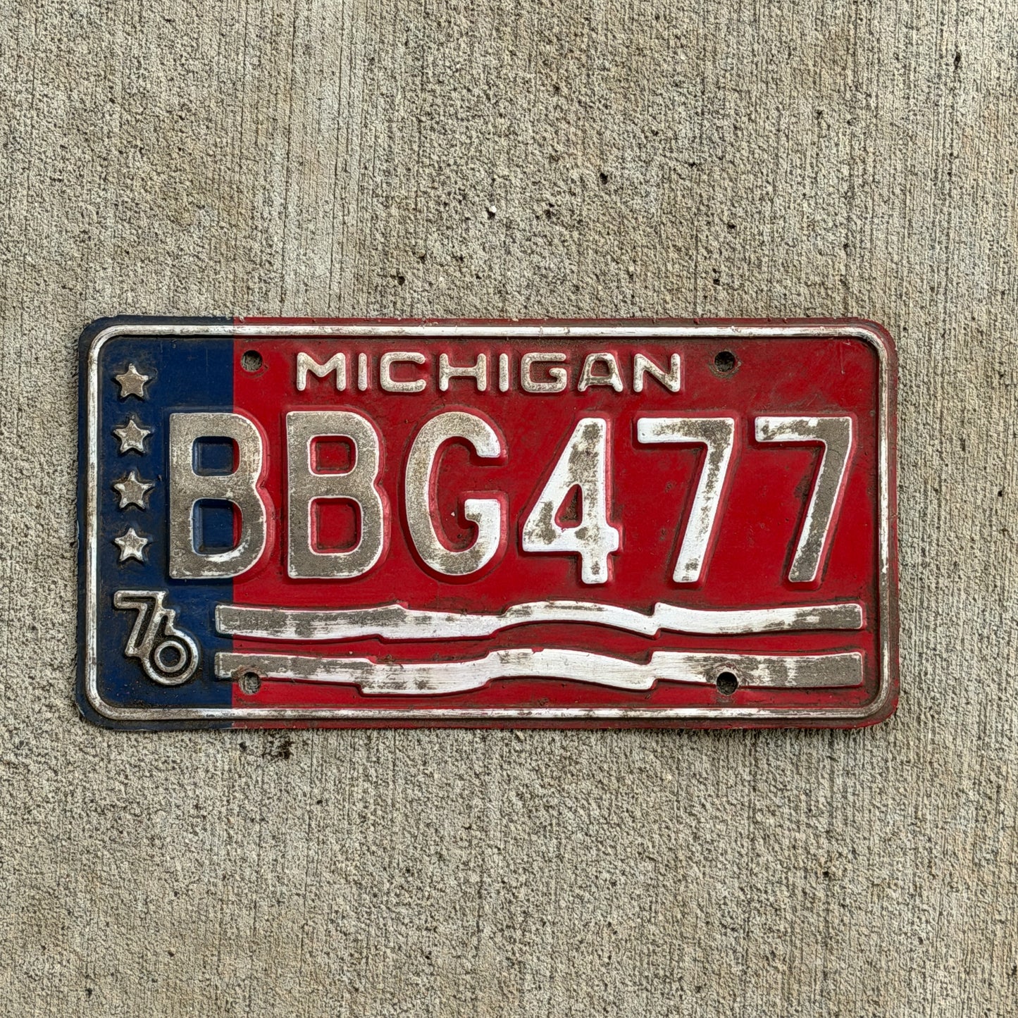 Photo of a 1976 Michigan License Plate Auto Tag Garage Decor Vintage Bicentennial BBG 477 with original patina