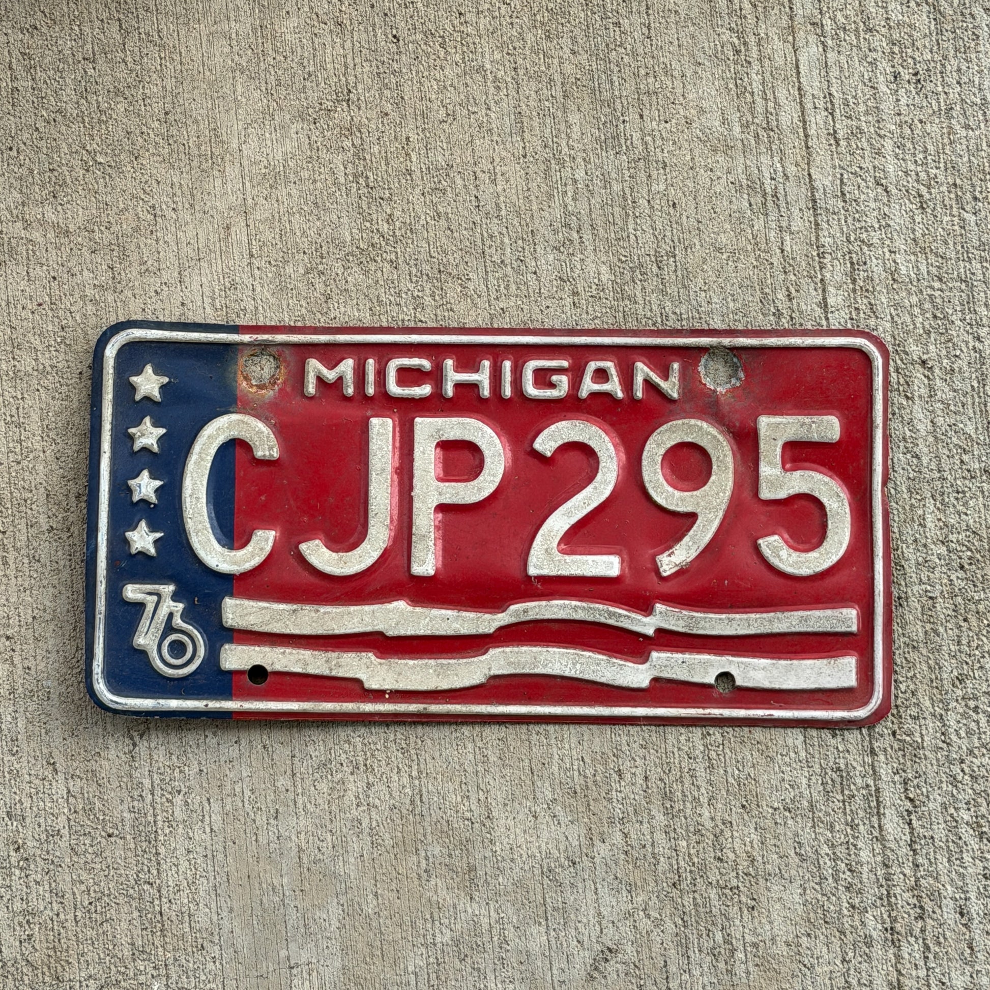 Photo of a 1976 Michigan License Plate Auto Tag Garage Decor Vintage Bicentennial CJP 295 with original patina