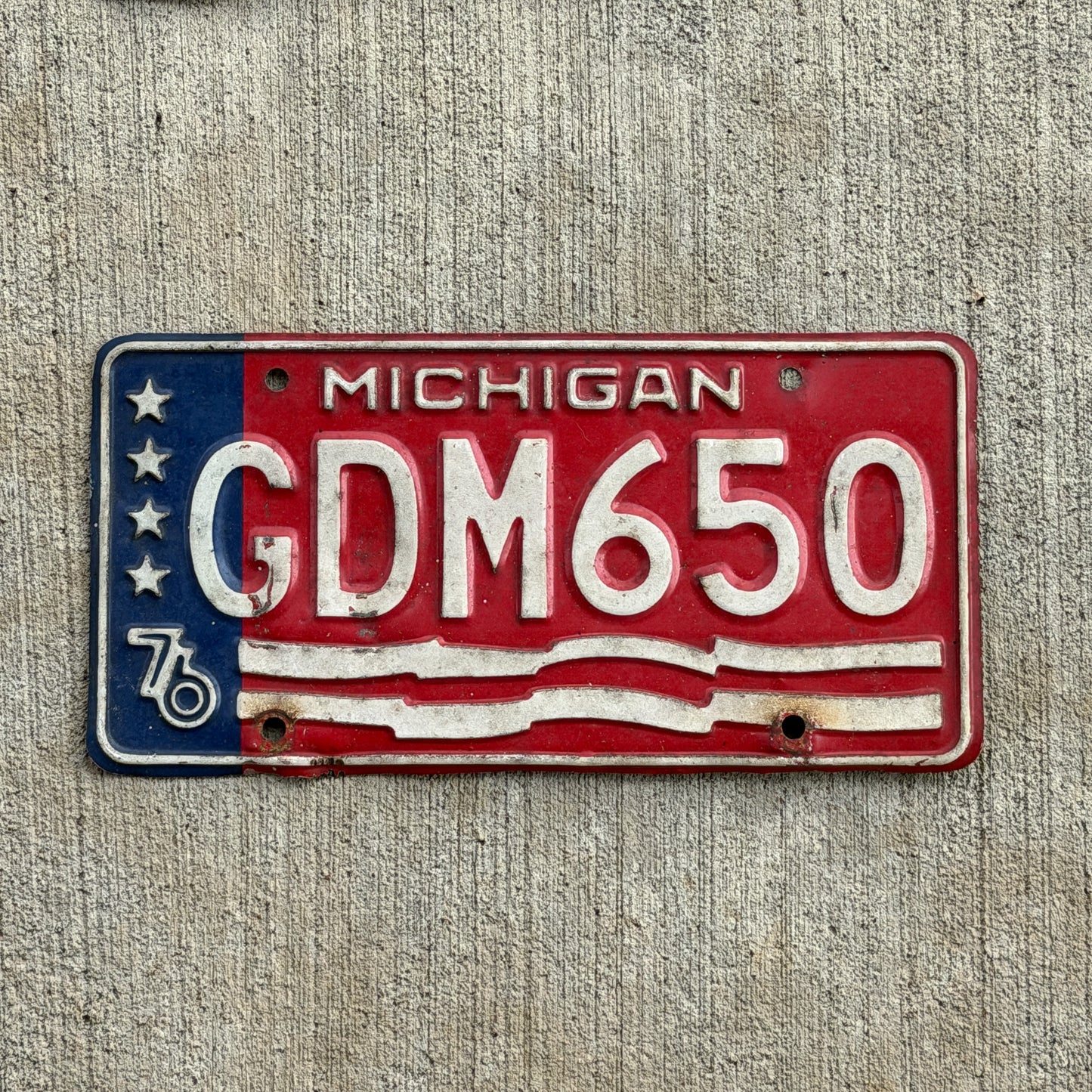 Photo of a 1976 Michigan License Plate Auto Tag Garage Decor Vintage Bicentennial GDM 650 with original patina