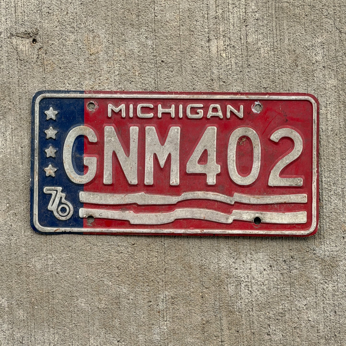 Photo of a 1976 Michigan License Plate Auto Tag Garage Decor Vintage Bicentennial GNM 402 with original patina