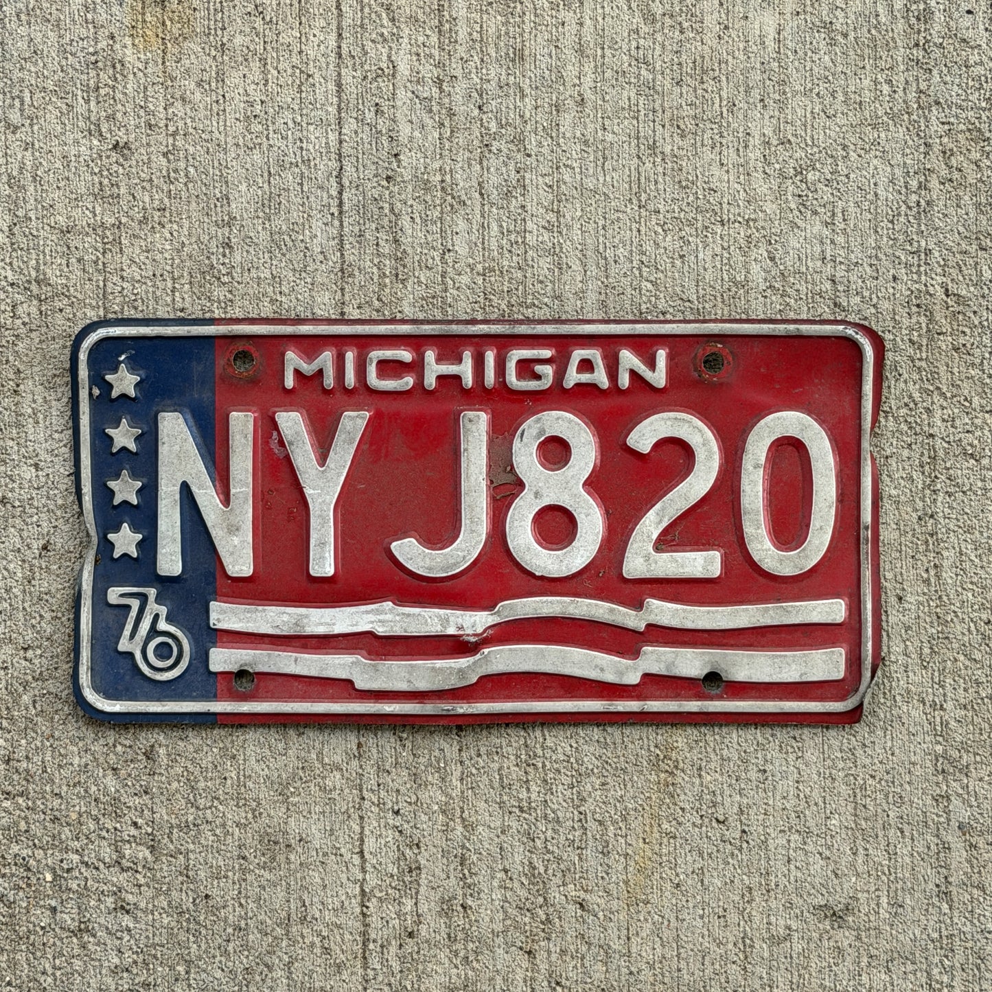 Photo of a 1976 Michigan License Plate Auto Tag Garage Decor Vintage Bicentennial NYJ 820 with original patina