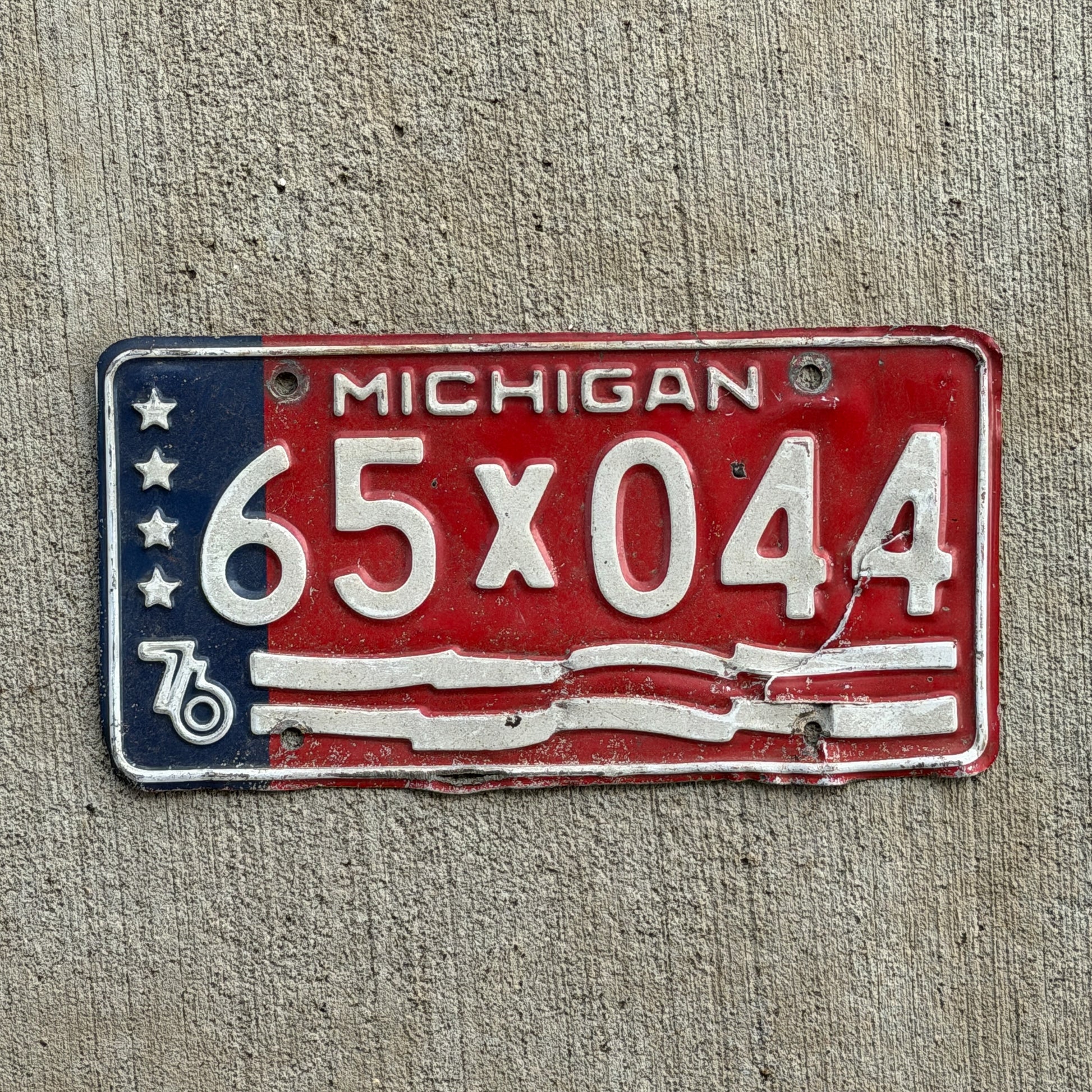 Photo of a 1976 Michigan Municipal License Plate Auto Tag Garage Decor Vintage Bicentennial 65 X 044 with original patina