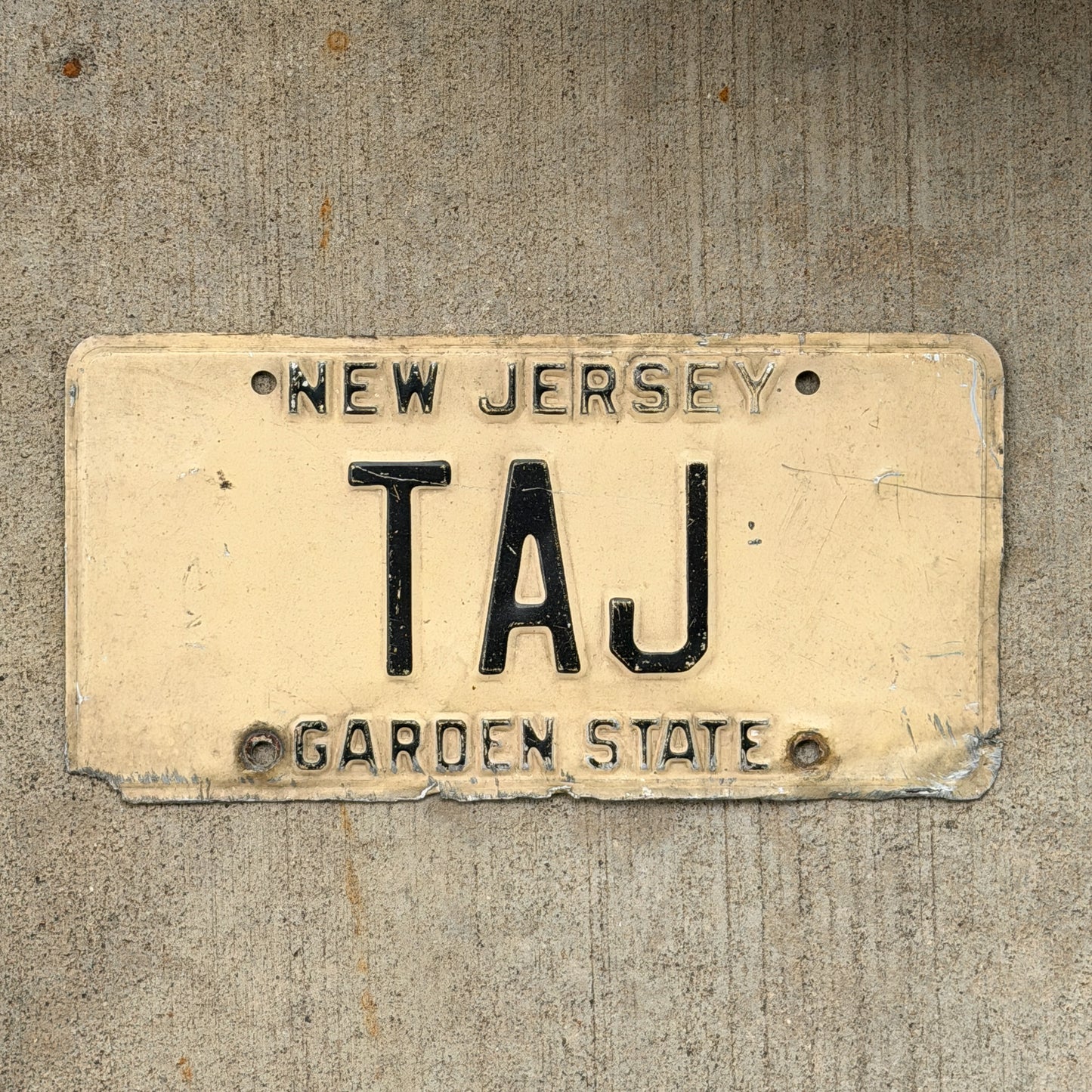Photo of a 1977 New Jersey Vanity License Plate Auto Tag Garage Decor Vintage TAJ with original patina