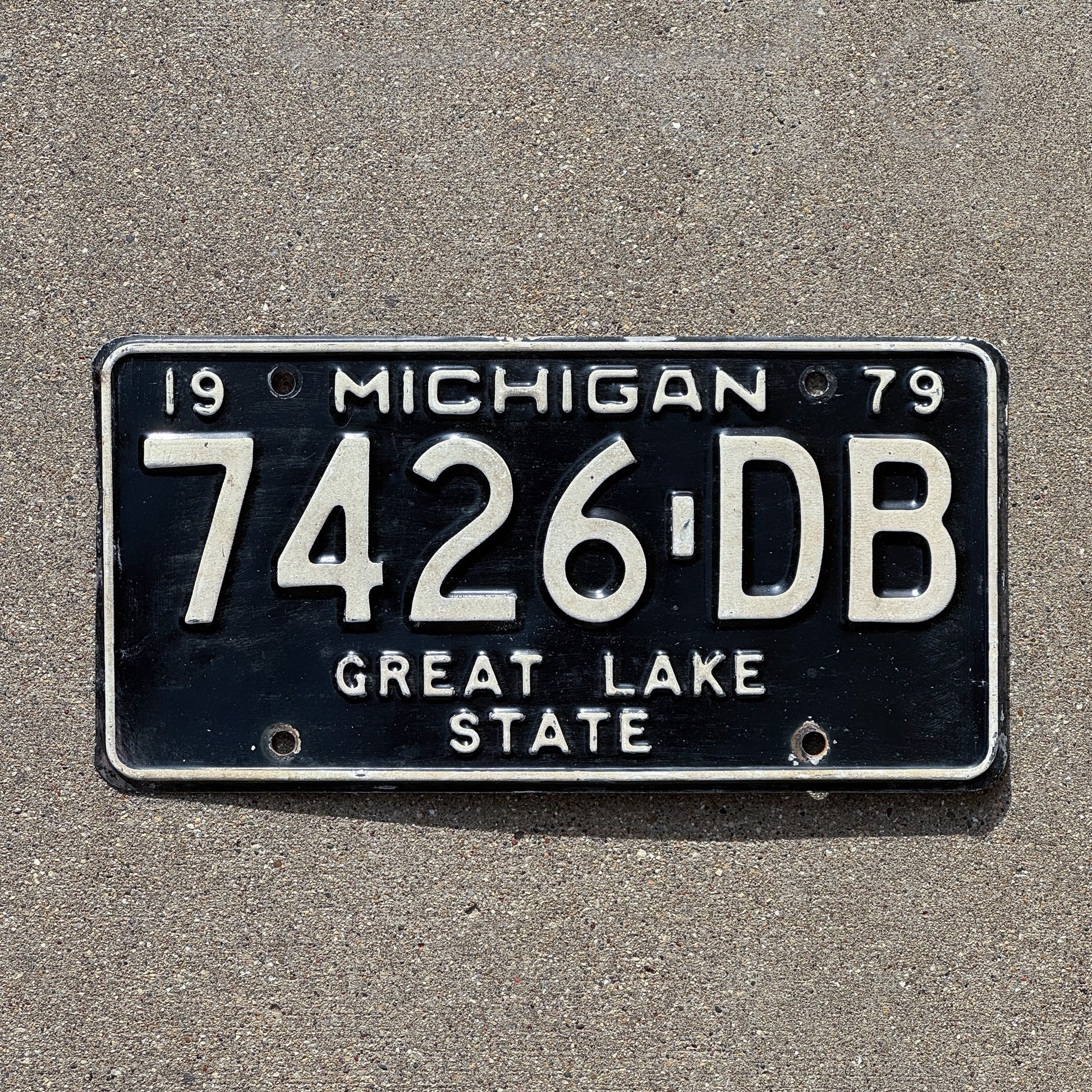 Photo of a 1979 Michigan Commercial License Plate Auto Tag Garage Decor Vintage 7426 DB with original patina