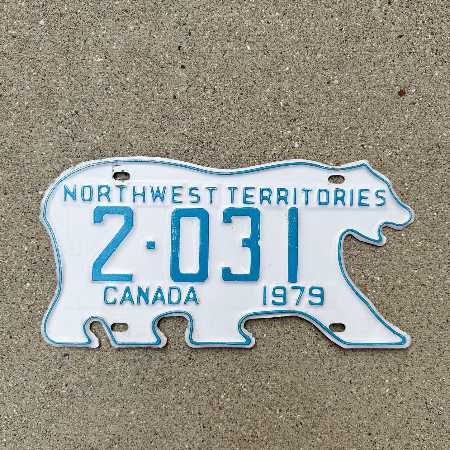 Photo of a 1979 Northwest Territories License Plate Auto Tag Garage Decor Vintage Low Number Four Digit Polar Bear 2 031 with original patina
