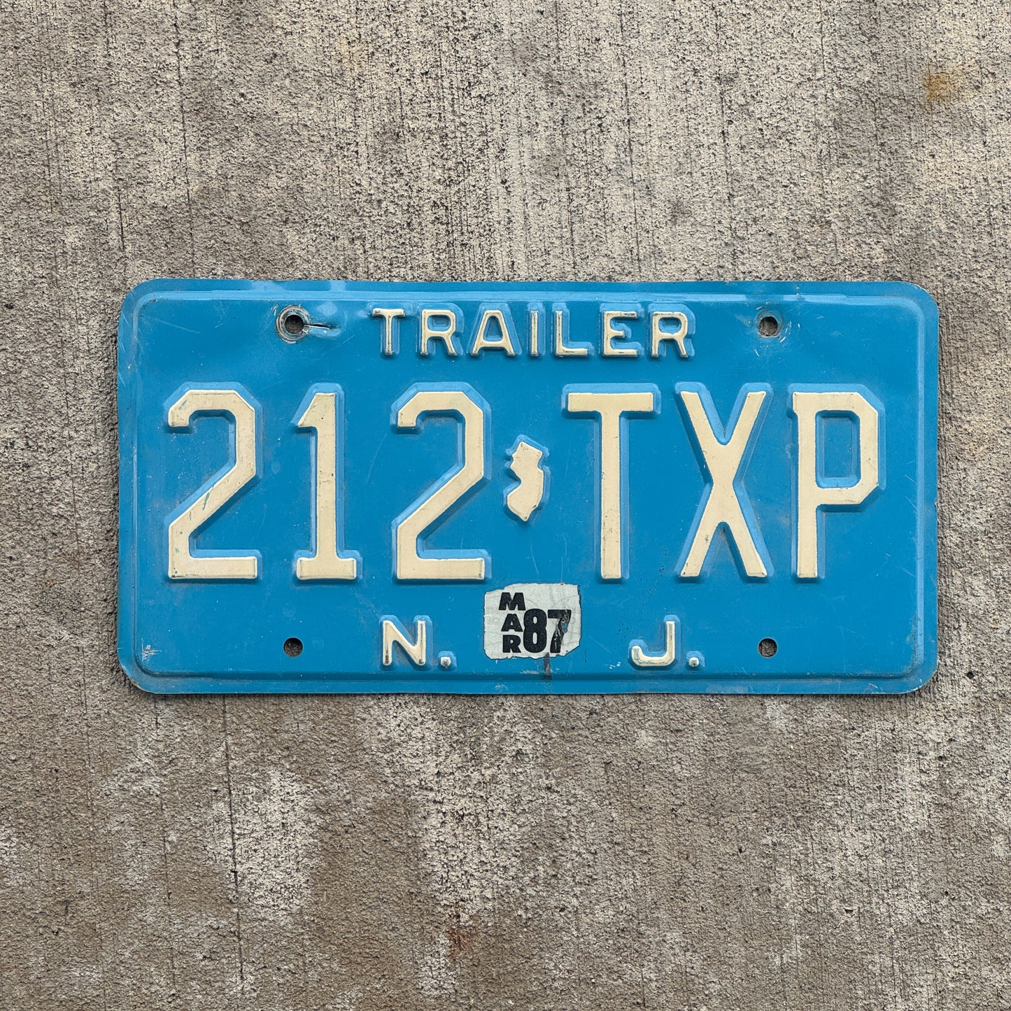 Photo of a 1980 1987 New Jersey Trailer License Plate Auto Tag Garage Decor Vintage Blue 212 TXP with original patina